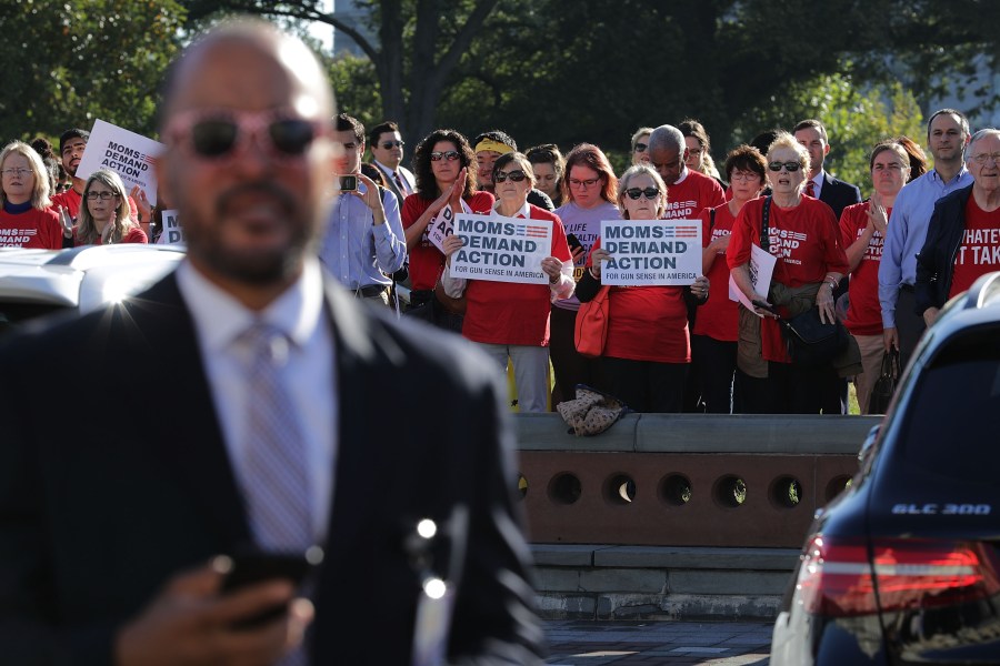 Anti-gun violence activists from Moms Demand Action stand at a distance as House Democrats rally on the East Front steps of the U.S. House of Representatives Oct. 4, 2017, in Washington, D.C. (Credit: Chip Somodevilla/Getty Images)