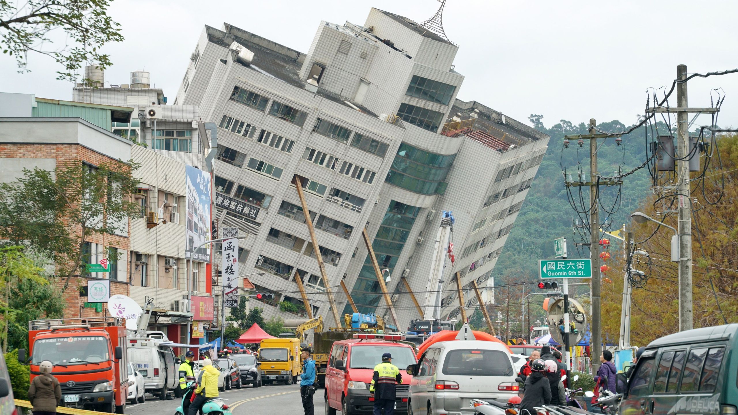 Rescue and emergency workers block off a street where a building came off its foundation, the morning after a 6.4 magnitude quake hit the eastern Taiwanese city of Hualien, on February 7, 2018. (Credit: PAUL YANG/AFP/Getty Images)