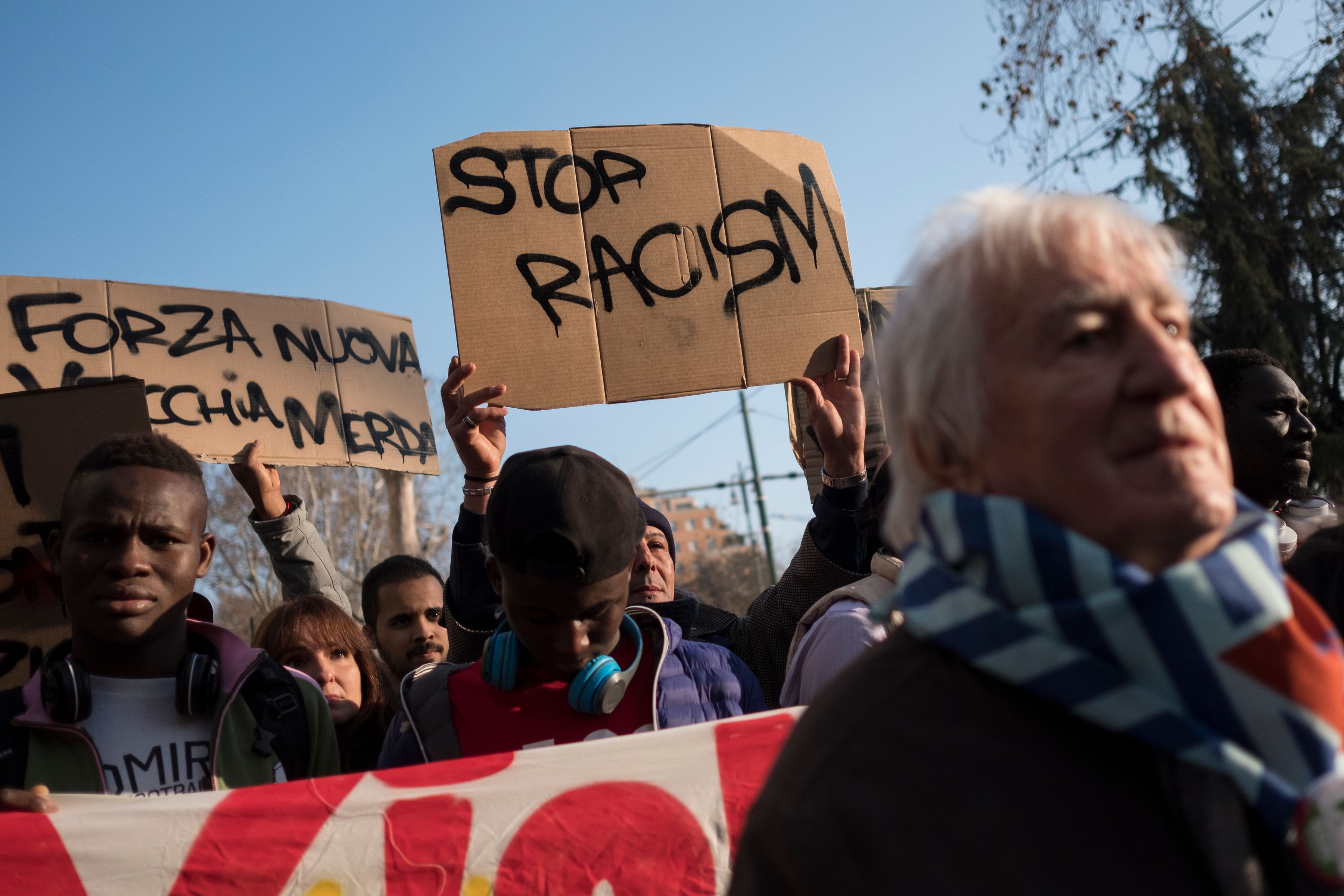 People hold placards reading "stop racism" during an anti-fascism demonstration on Feb. 10, 2018, in Milan, one week after an attack that injured at least six migrants in the central Italian town of Macerata. (Credit: MARCO BERTORELLO/AFP/Getty Images)