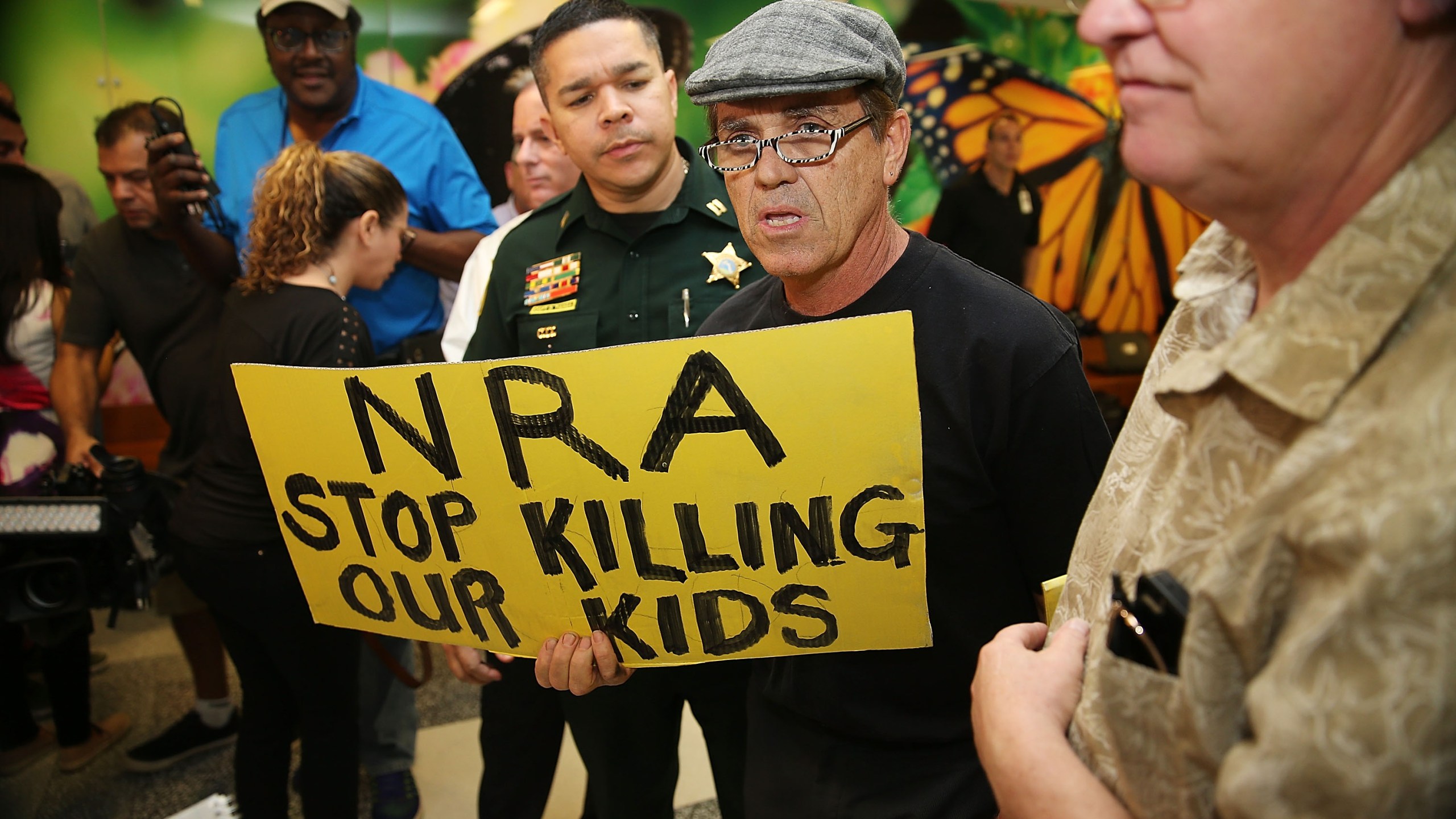 A protester holds a sign that reads "NRA Stop Killing Our Kids" outside Broward County Courthouse, where Nikolas Cruz was having a bond hearing on Feb. 15, 2018 in Fort Lauderdale, Florida. (Credit: Charles Trainor Jr. - Pool/Getty Images)