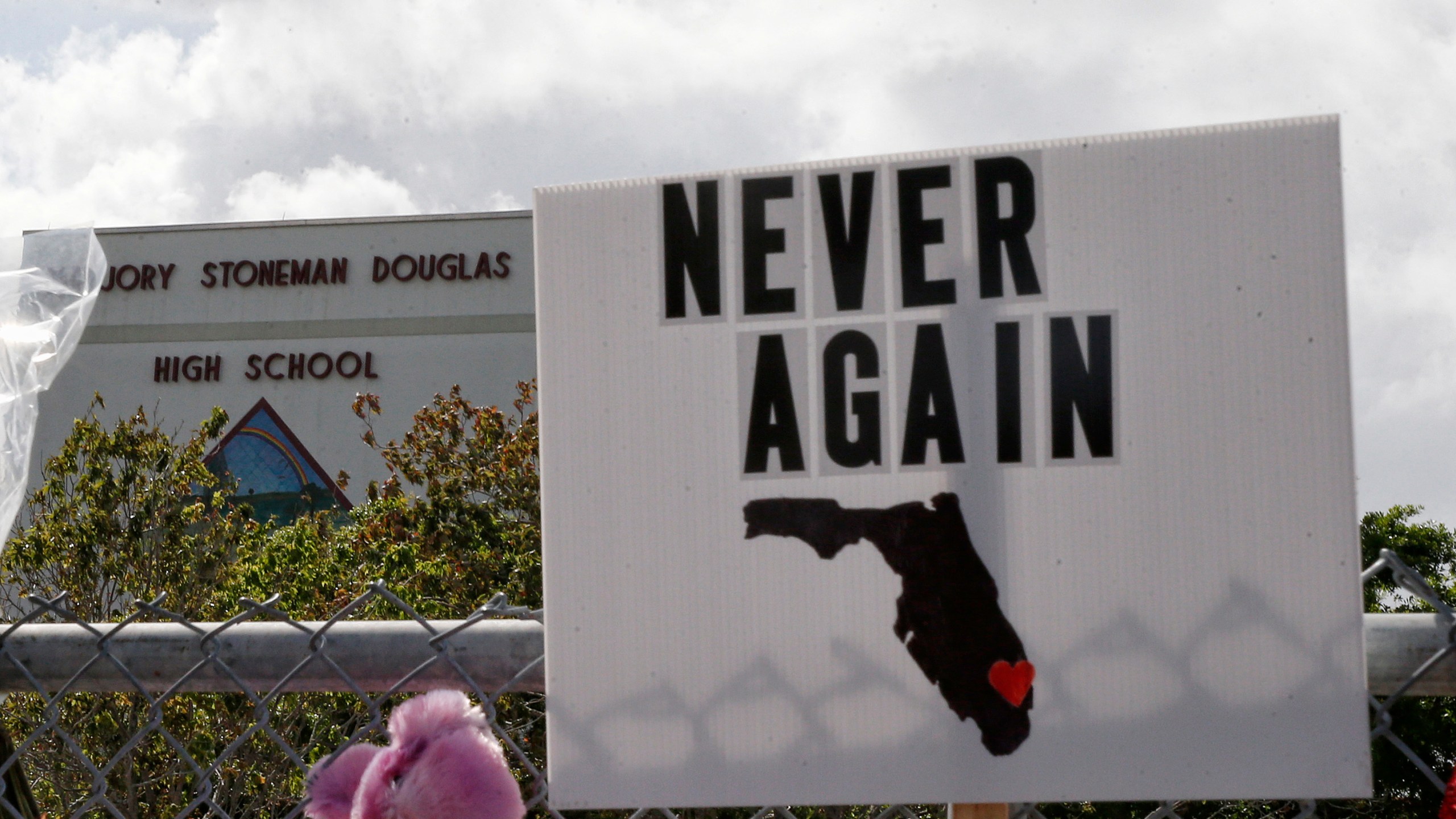 Memorials are seen on a fence surrounding Marjory Stoneman Douglas High School in Parkland, Florida, on Feb. 21, 2018. (Credit: RHONA WISE/AFP/Getty Images)