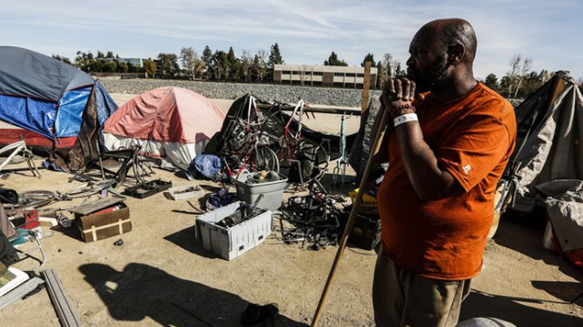 Arthur Johnson looks out toward his items that have to cleaned up and stored along the Santa Ana River. (Credit: Maria Alejandra Cardona / Los Angeles Times)