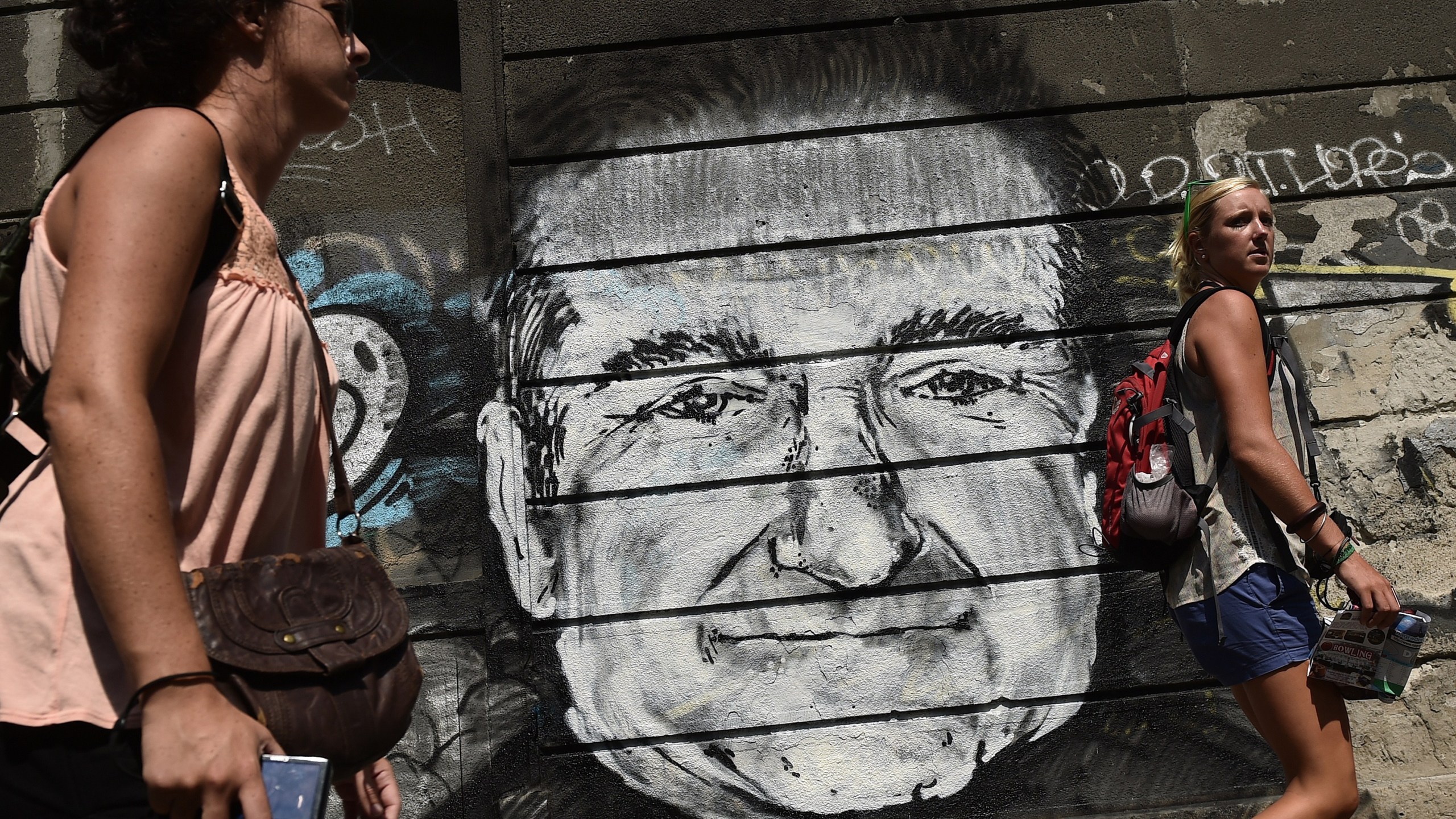 People walk past a mural depicting actor Robin Williams in downtown Belgrade on Aug. 13, 2014. (Credit: ANDREJ ISAKOVIC/AFP/Getty Images)