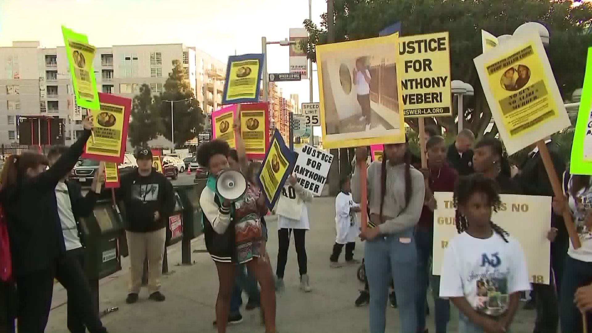 Keyanna Celina talks into a loudspeaker as protesters take to Figueroa Street outside the Staples Center in downtown Los Angeles on Feb. 18, 2018, to call for the prosecution of sheriff's deputies involved in the shooting of a black teen in Westmont. (Credit: KTLA)