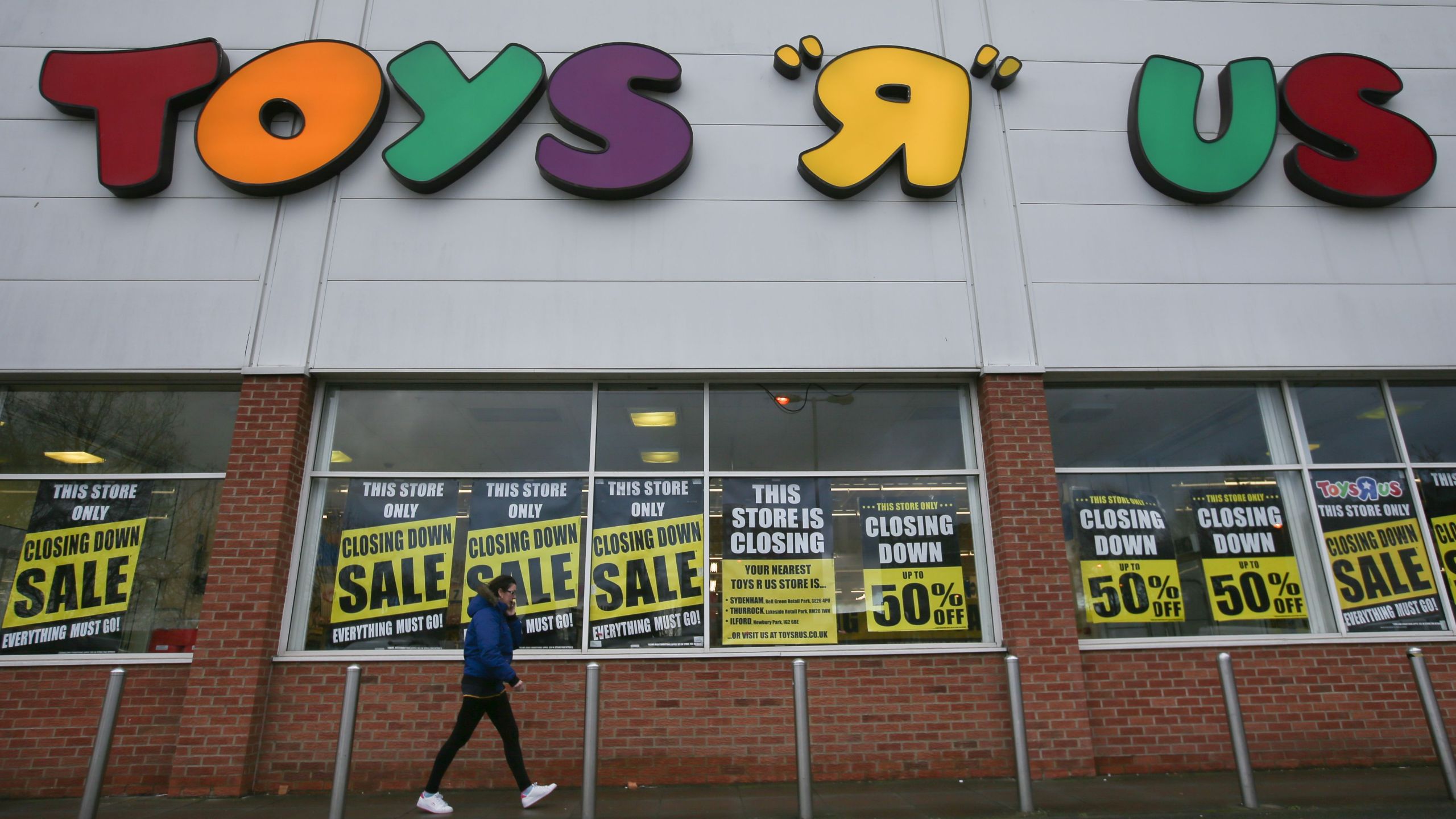 A customer walks outside a Toys "R" Us store with "closing down sale" signs in the windows in south London on Feb. 9, 2018. (Credit: DANIEL LEAL-OLIVAS/AFP/Getty Images)