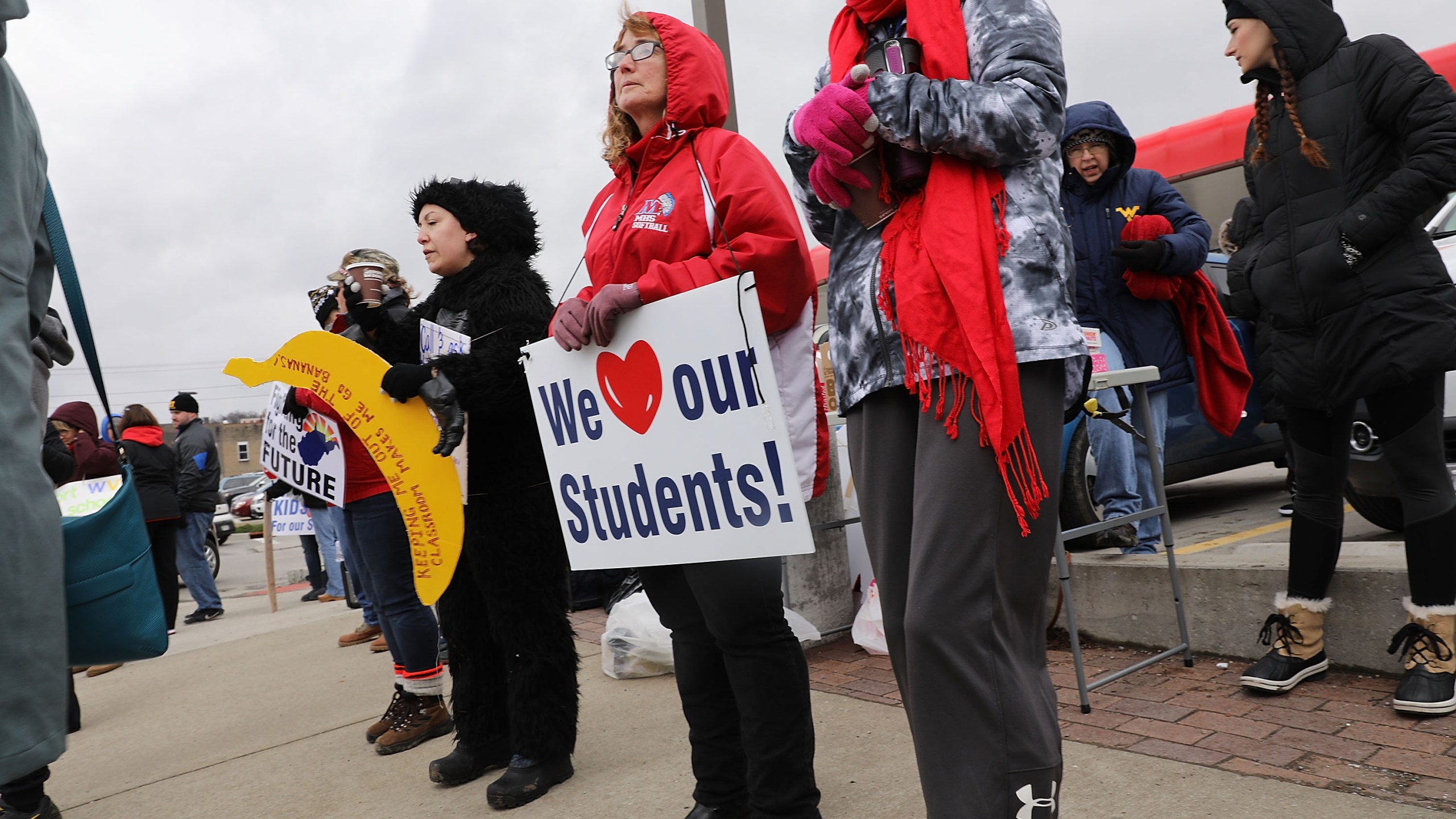 West Virginia teachers, students and supporters hold signs on a Morgantown street as they continue their strike on March 2, 2018, in Morgantown, West Virginia. (Credit: Spencer Platt/Getty Images)