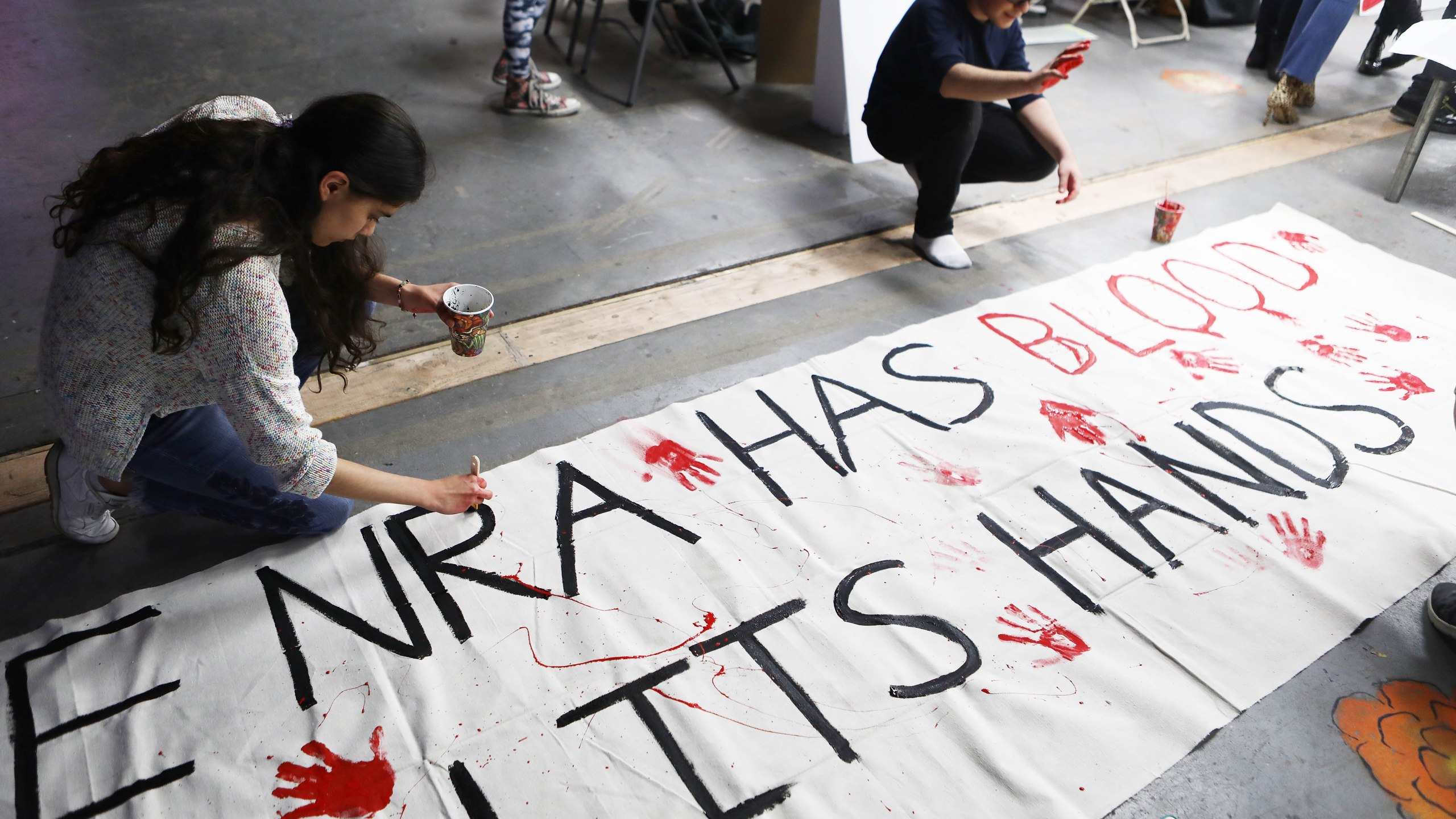 Young activists paint signs to be carried at the upcoming March for Our Lives Los Angeles on March 22, 2018 in Los Angeles, California. (Credit: Mario Tama/Getty Images)