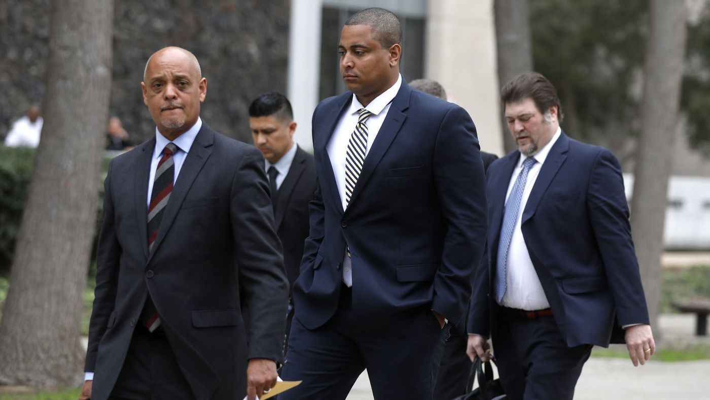 Jonathan Martin, center, walks with his attorney Winston McKesson, left, to be booked at the Los Angeles Police Department after pleading not guilty to making criminal threats at the Van Nuys Courthouse on March 20, 2018. (Credit: Gary Coronado / Los Angeles Times)