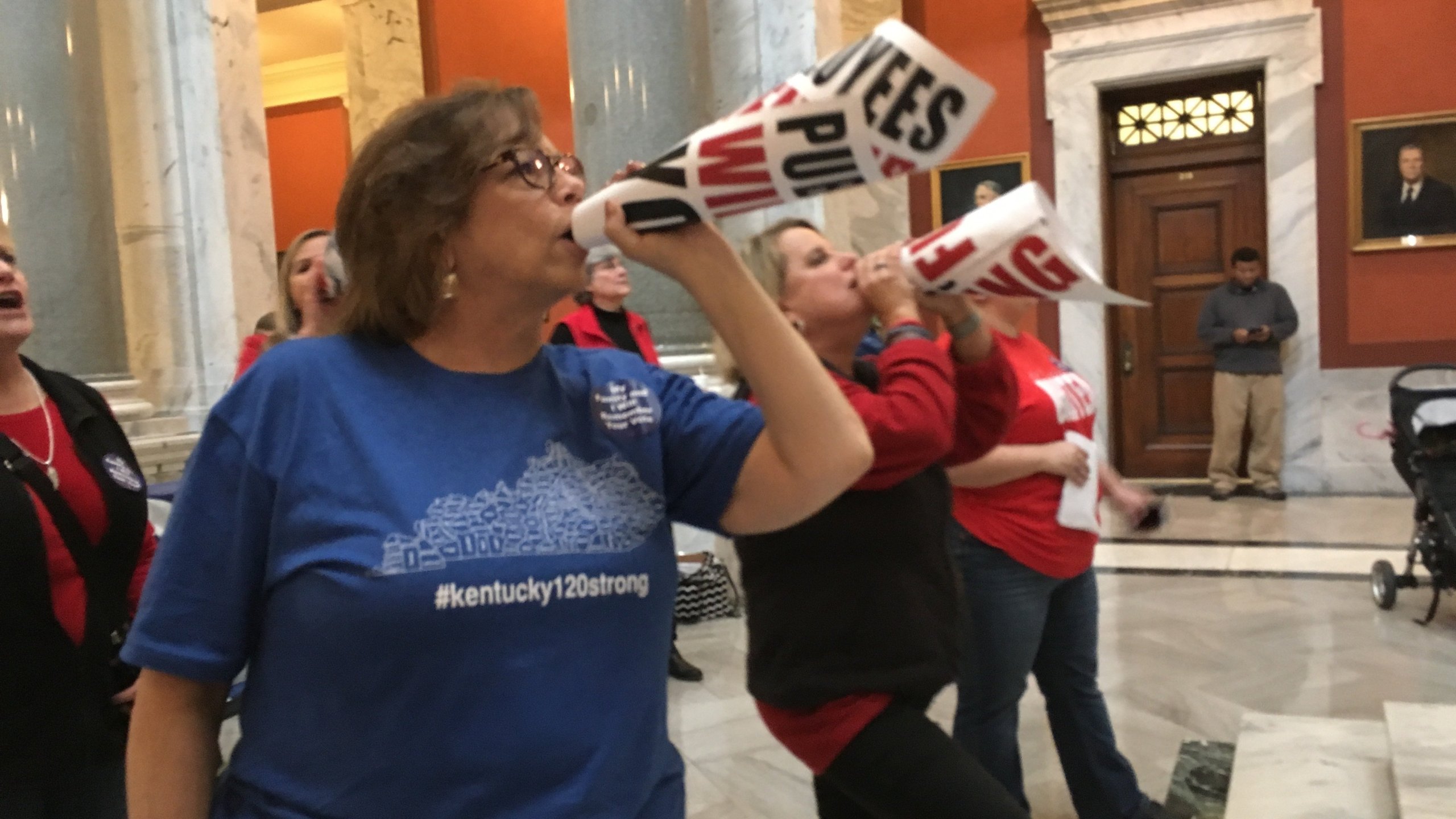 Retired teacher Lydia Coffey chants "Vote them out" as lawmakers in Kentucky debate a bill to make changes to the state's pension system. (Credit: AP via CNN)