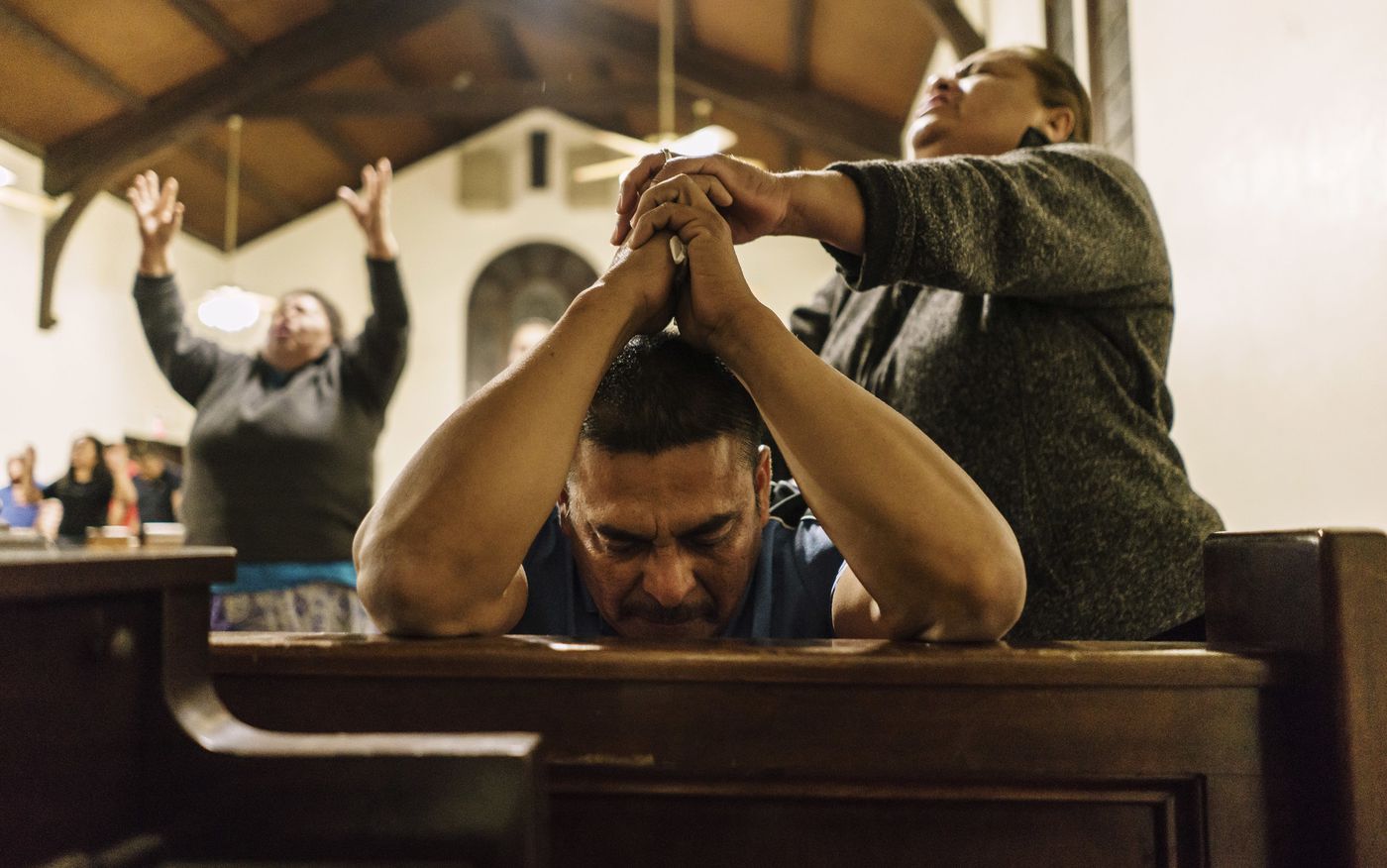 Jesus Aceves, center, who was detained by Immigration and Customs Enforcement agents, prays at his brother's church, El Aposento Alto, in Wasco. Aceves was released on bond and is awaiting a hearing before an immigration judge. (Credit: Marcus Yam / Los Angeles Times)