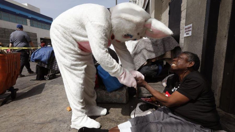 The Easter bunny prays with Anntony, a homeless woman, at the Midnight Mission's annual Easter brunch on skid row, April 1, 2018. (Credit: Genaro Molina / Los Angeles Times)