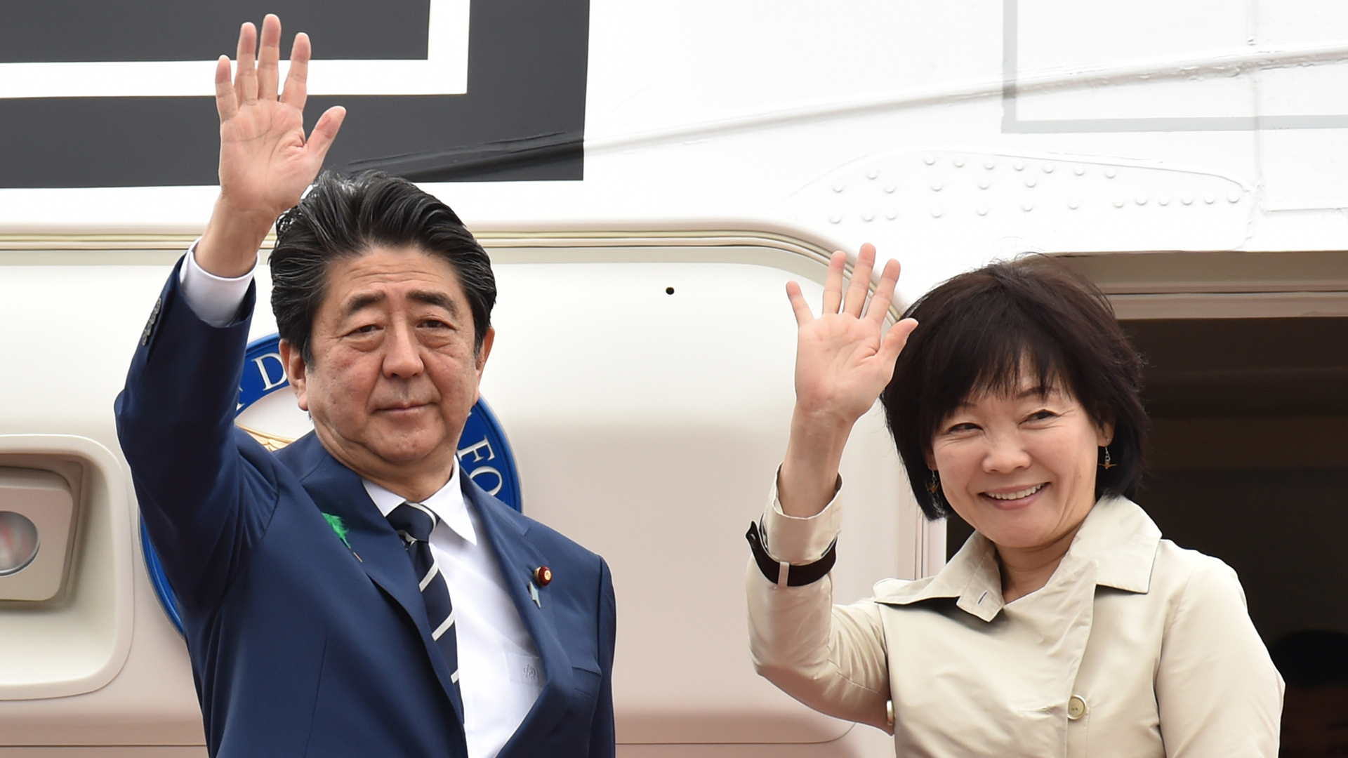 Japan's Prime Minister Shinzo Abe and his wife Akie wave as they depart for the U.S. from Tokyo's Haneda airport on April 17, 2018. (Credit Kazuhiro Nogi/AFP/Getty Images)