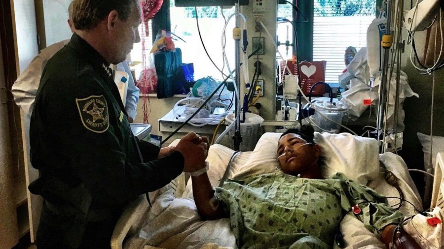 Sheriff Scott Israel holds the hand of Anthony Borge, a student who shot five times in the massacre. (Credit: Broward County Sheriff's Office)