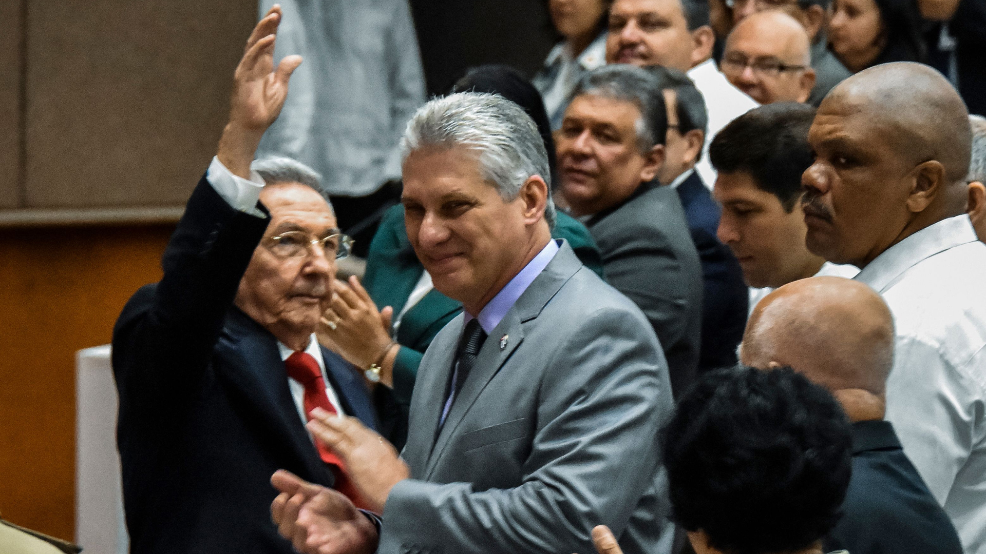 Cuban President Raul Castro (left) waves next to First Vice-President Miguel Diaz-Canel (center) during a National Assembly session that will select Cuba's Council of State ahead of the naming of a new president, in Havana on April 18, 2018. (Credit: STR/AFP/Getty Images)