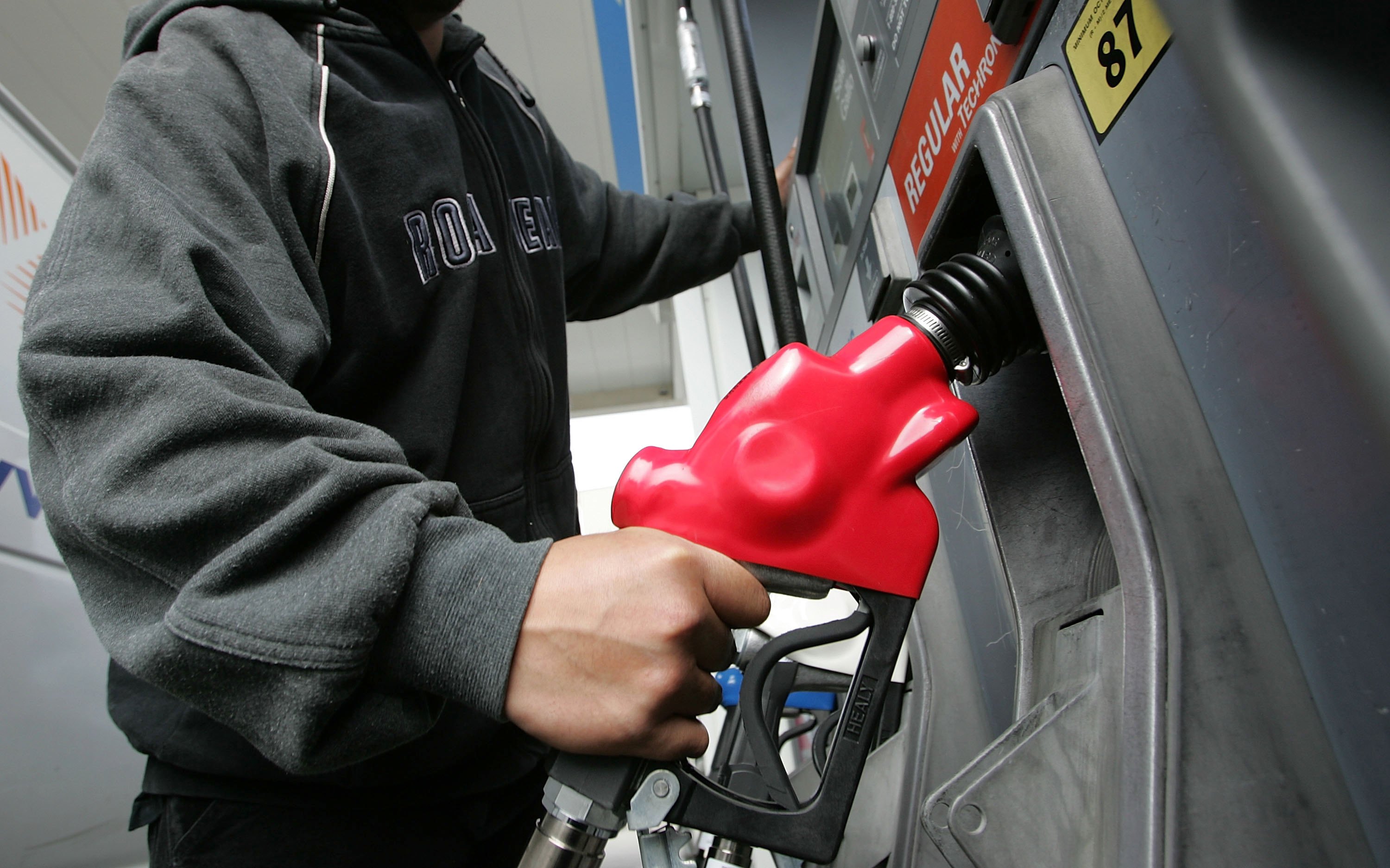 Don Resuerco holds a gas pump before pumping gas into his work van March 27, 2006 in San Francisco. (Credit: Justin Sullivan/Getty Images)