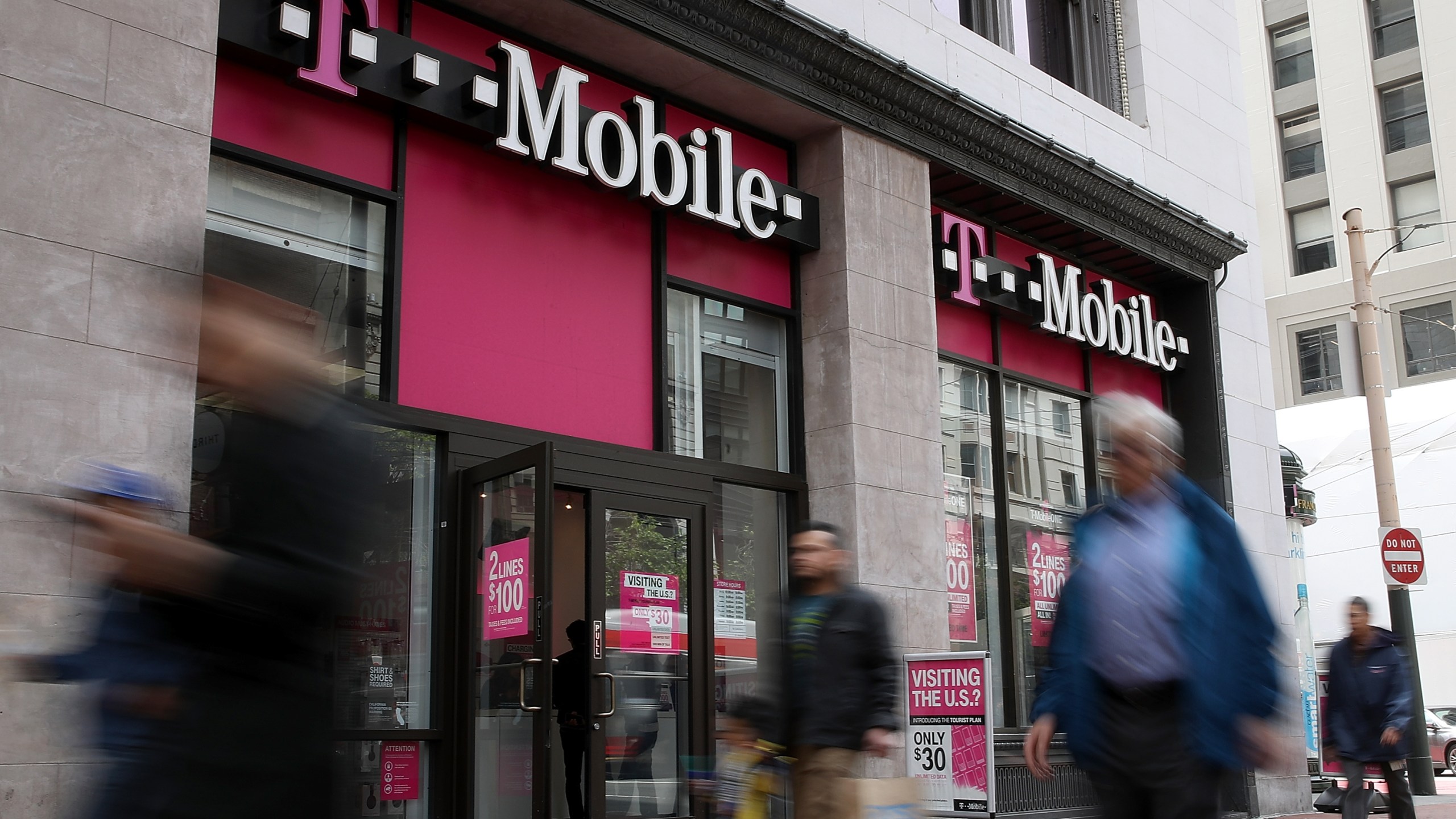 Pedestrians walk by a T-Mobile store in San Francisco on on April 24, 2017. (Credit: Justin Sullivan/Getty Images)