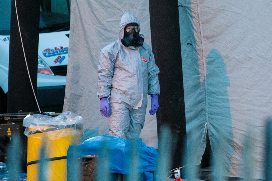 A police officer in a forensics suit and protective mask stands by a forensics tent outside a vehicle recovery centre as investigations continue into the poisoning of Sergei Skripal on March 13, 2018 in Salisbury, England. (Credit: Jack Taylor/Getty Images)