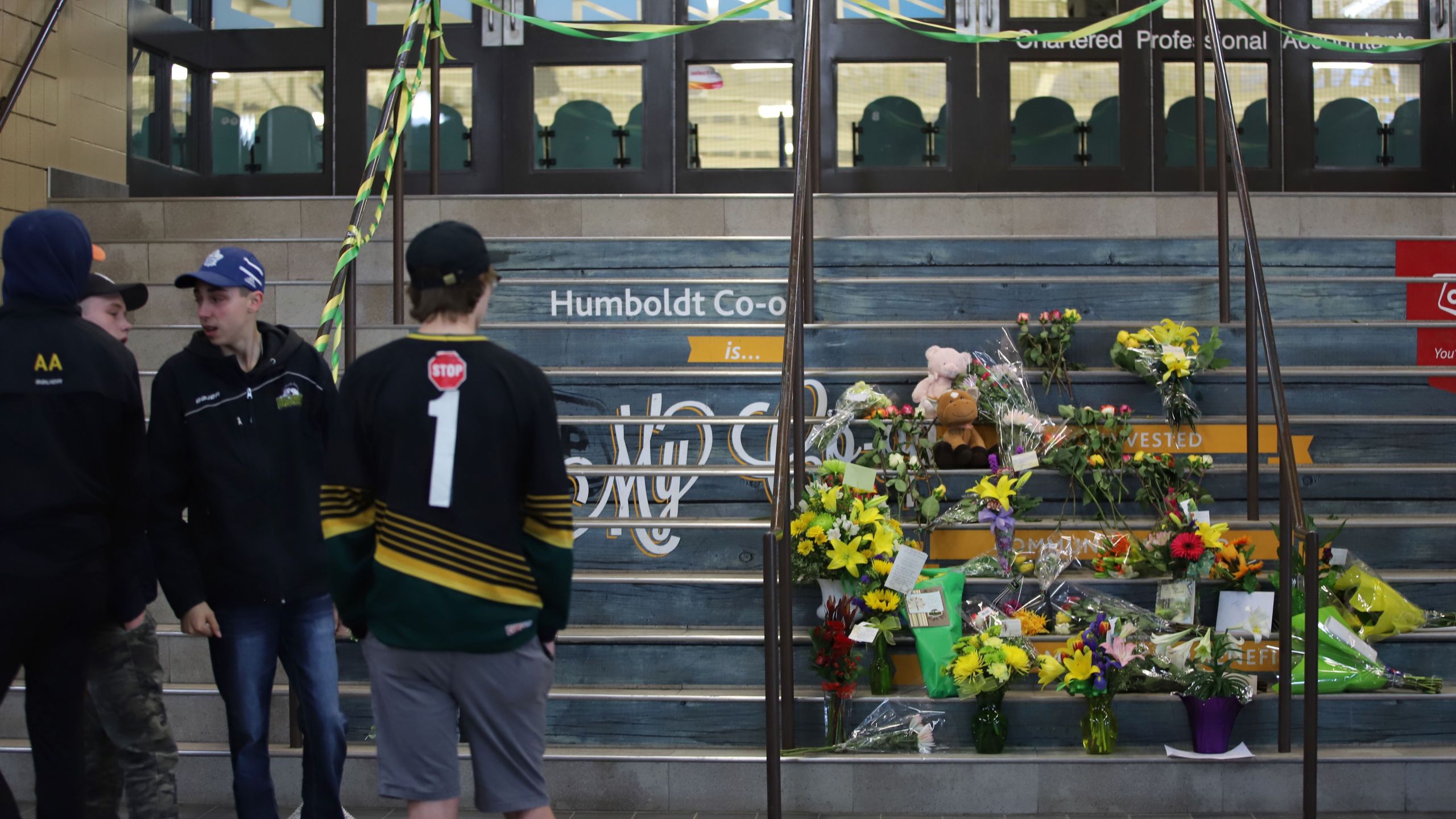 Flowers are left outside the Humboldt Uniplex ice-skating rink on April 7, 2018 in Humboldt, Saskatchewan after a bus carrying a junior ice hockey team collided with a semi-trailer truck near Tisdale and Nipawin, Saskatchewan province, killing 14 people. (Credit: KYMBER RAE/AFP/Getty Images)