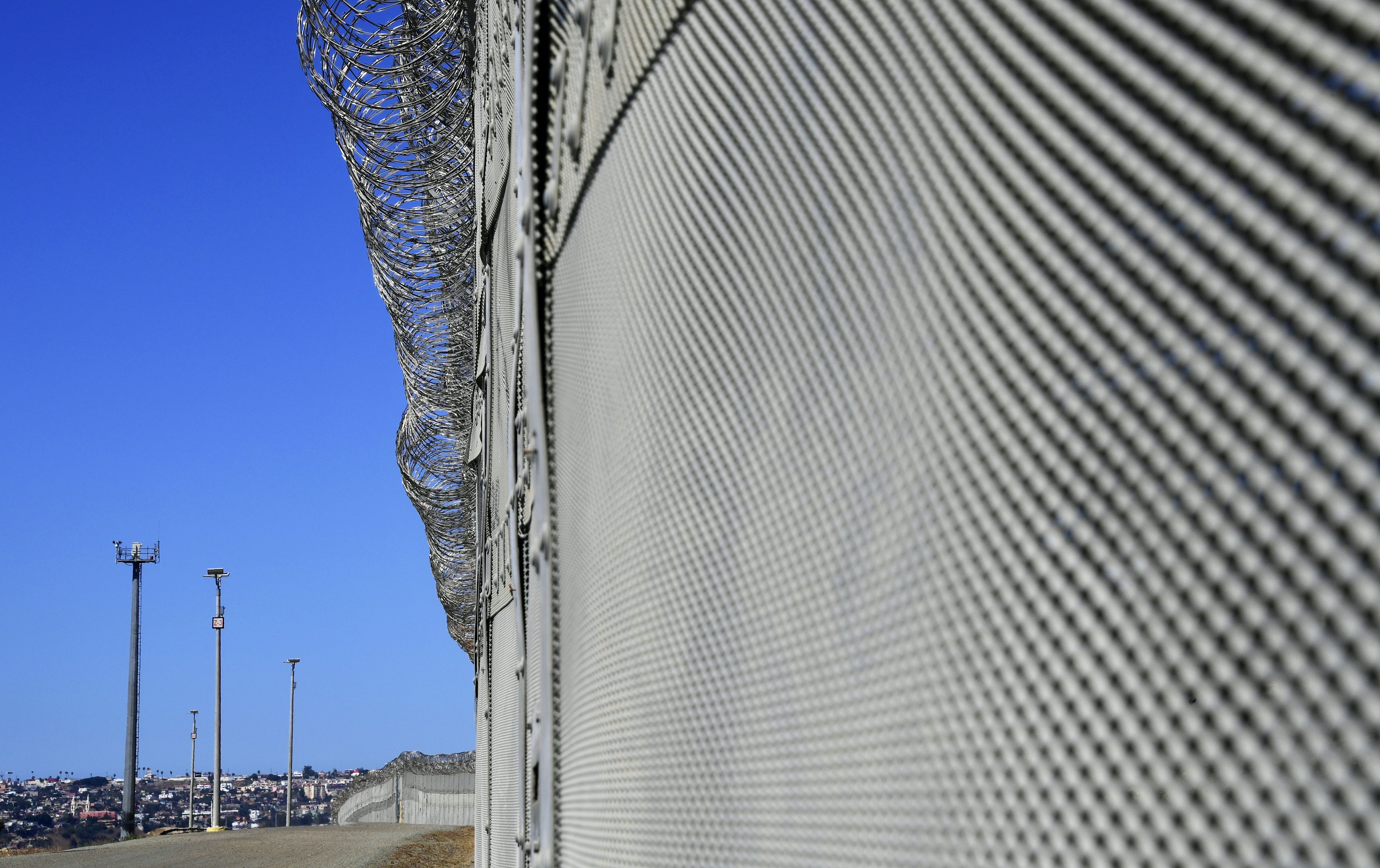 Barbed wire fencing runs across the top of the steel structure in the Border Infrastructure System in San Diego on April 17, 2018. (Credit: FREDERIC J. BROWN/AFP/Getty Images)