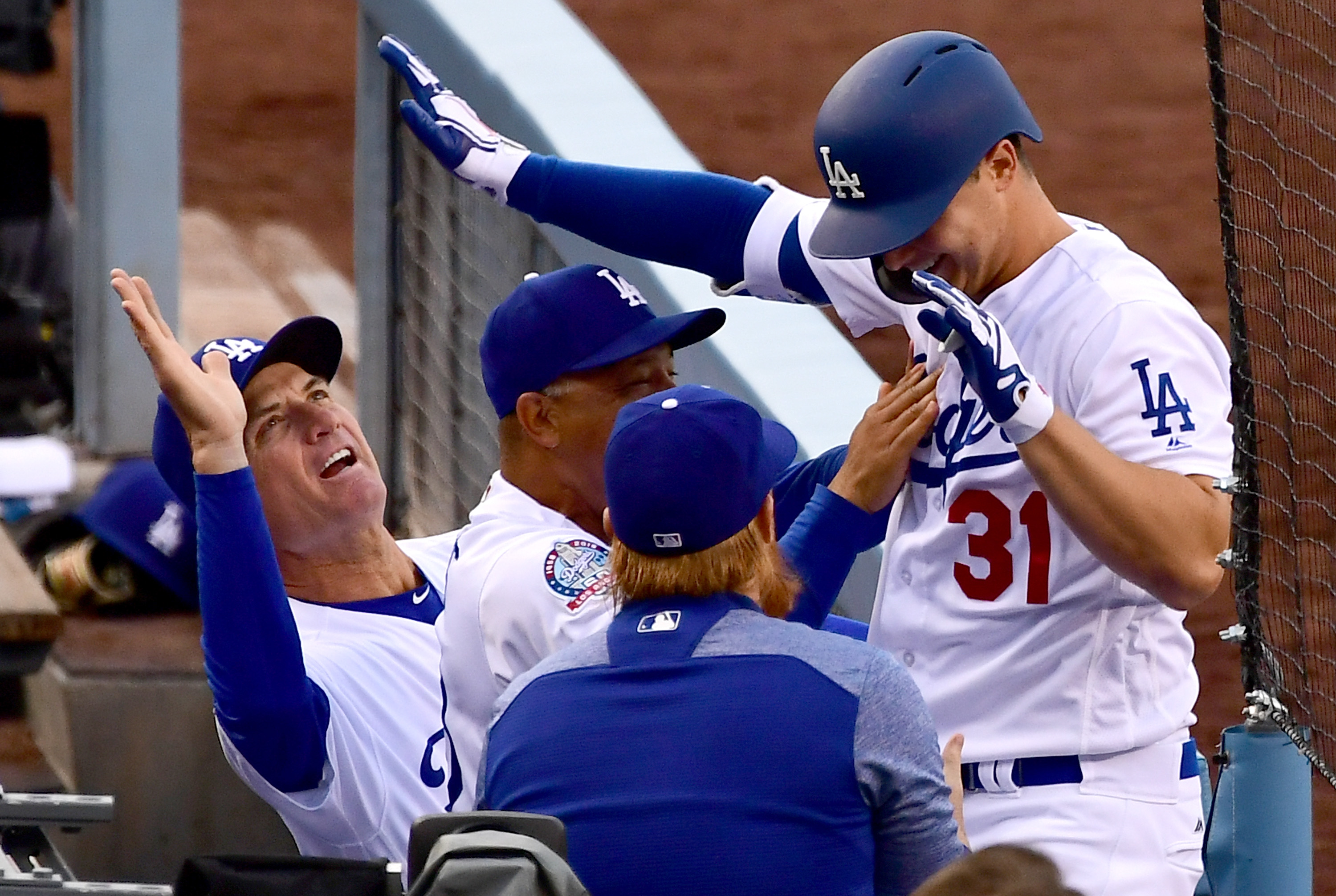 Joc Pederson is greeted in the dugout by bench coach Bob Geren and Dave Roberts of the Los Angeles Dodgers after hitting a solo home run in the second inning of the game against the Washington Nationals at Dodger Stadium on April 21, 2018. (Credit: Jayne Kamin-Oncea / Getty Images)