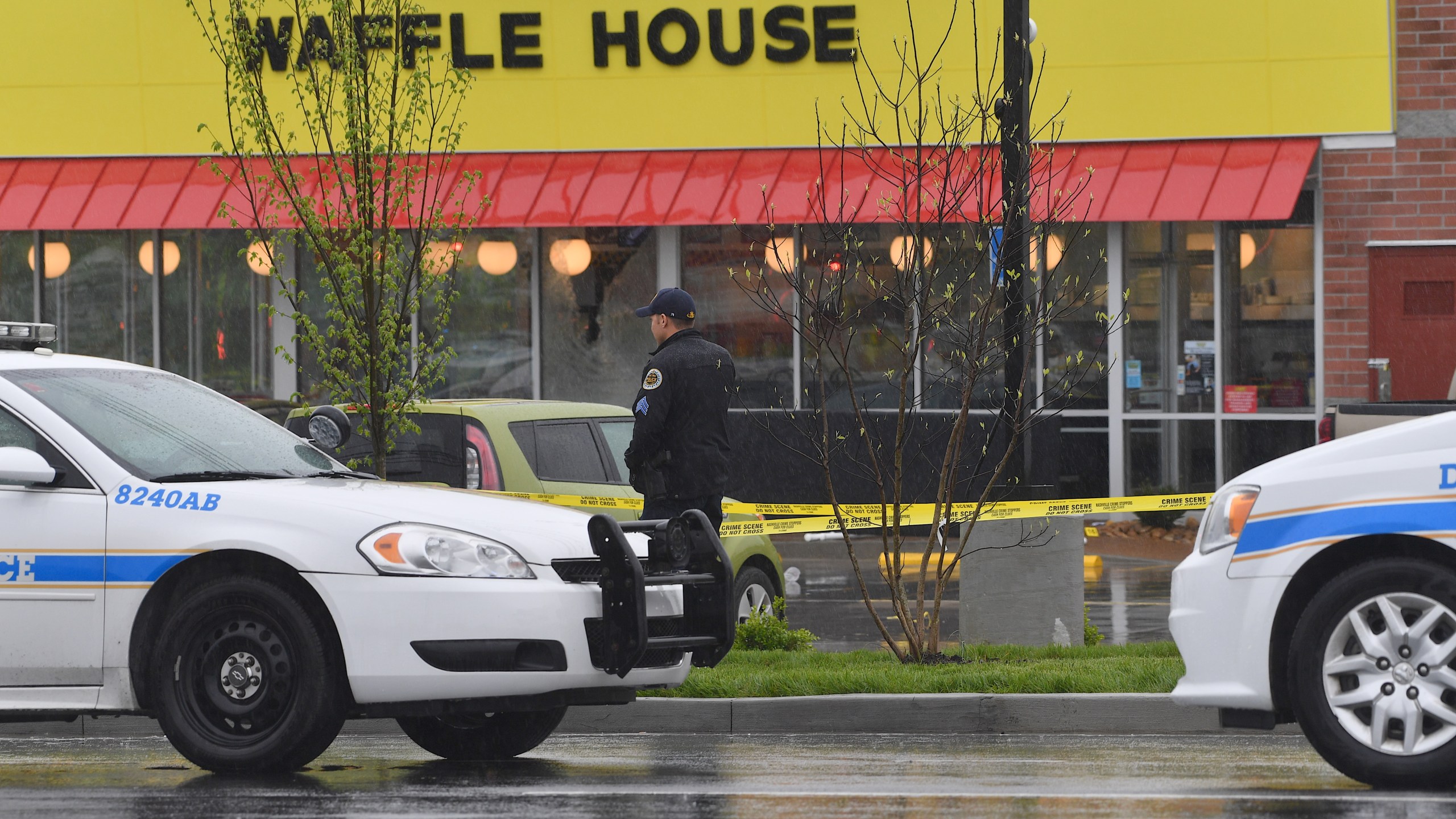 A law enforcement officer stands outside a Waffle House where four people were killed and two were wounded after a gunman opened fire with an assault weapon on April 22, 2018 in Nashville, Tennessee. (Credit: Jason Davis/Getty Images)