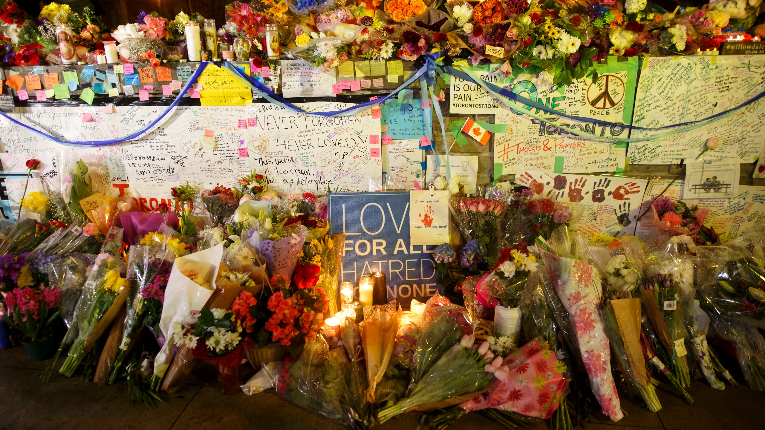 Flowers, cards, and words of sympathy adorn a makeshift memorial for victims of the mass killing on April 24, 2018 in Toronto, Canada. (Credit: Cole Burston/Getty Images)