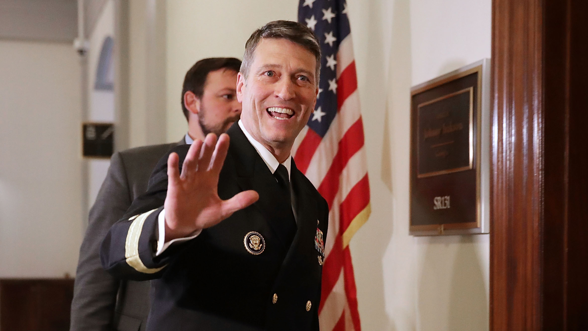 Physician to the President U.S. Navy Rear Admiral Ronny Jackson waves to journalists as he heads into a meeting with Senate Veterans Affairs Committee Chairman Johnny Isakson (R-GA) in the Russell Senate Office Building on Capitol Hill April 16, 2018, in Washington, D.C. (Credit: Chip Somodevilla/Getty Images)