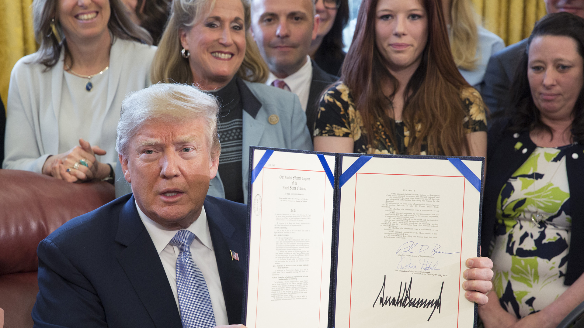 Donald Trump displays H.R. 1865, the "Allow States and Victims to Fight Online Sex Trafficking Act of 2017" after signing it into law at the White House on April 11, 2018. (Credit: Chris Kleponis-Pool/Getty Images)