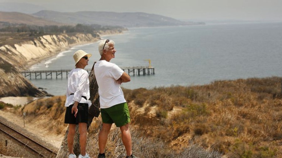 Jeff Kamer, right, of Goleta, shows Debby Kamer,his visiting sister, the view of the ocean at the entrance to Hollister Ranch. Its owners seek to block a public access attempt by the California Coastal Commission to the shoreline of the secluded ranch, which is tucked between the Santa Ynez Mountains and Pacific Ocean in this undated photo. (Credit: Al Seib / Los Angeles Times)