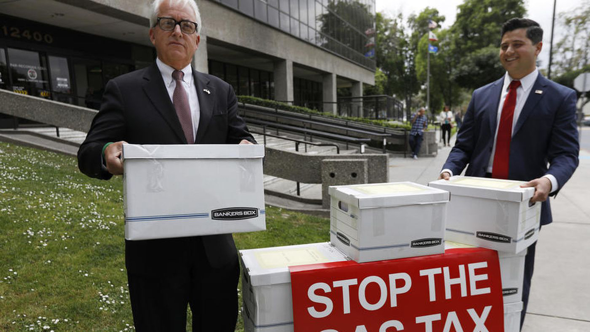 Gubernatorial candidate John Cox, left, and Assembly candidate Bill Essayli load boxes of signatures for the gas tax repeal initiative. (Credit: Francine Orr / Los Angeles Times)