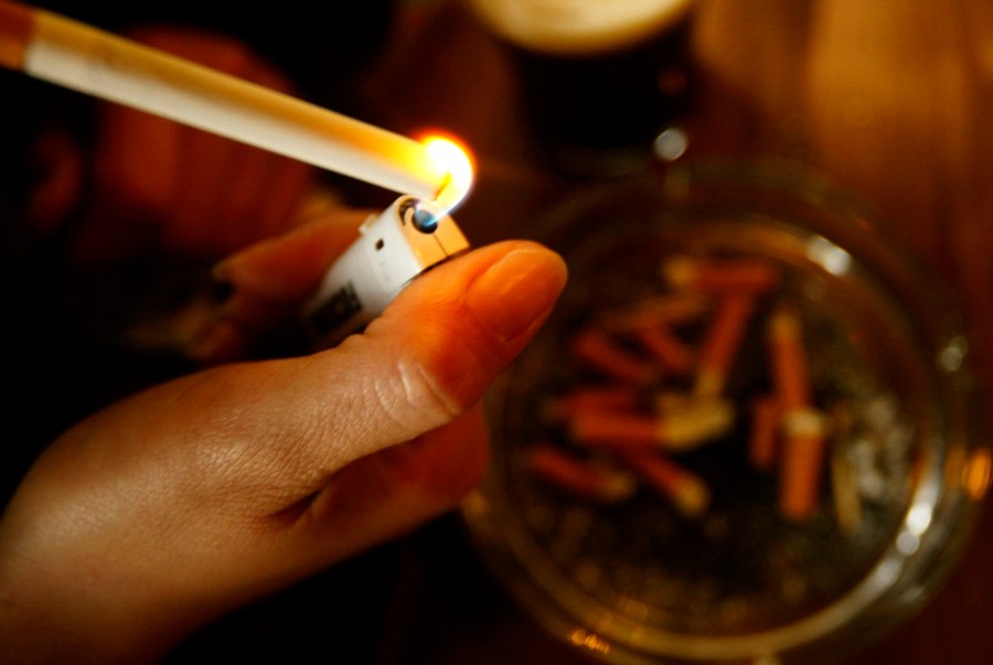 A girl lights up a cigarette in this file photo taken on January 9, 2004. (Credit: Graeme Robertson/Getty Images)