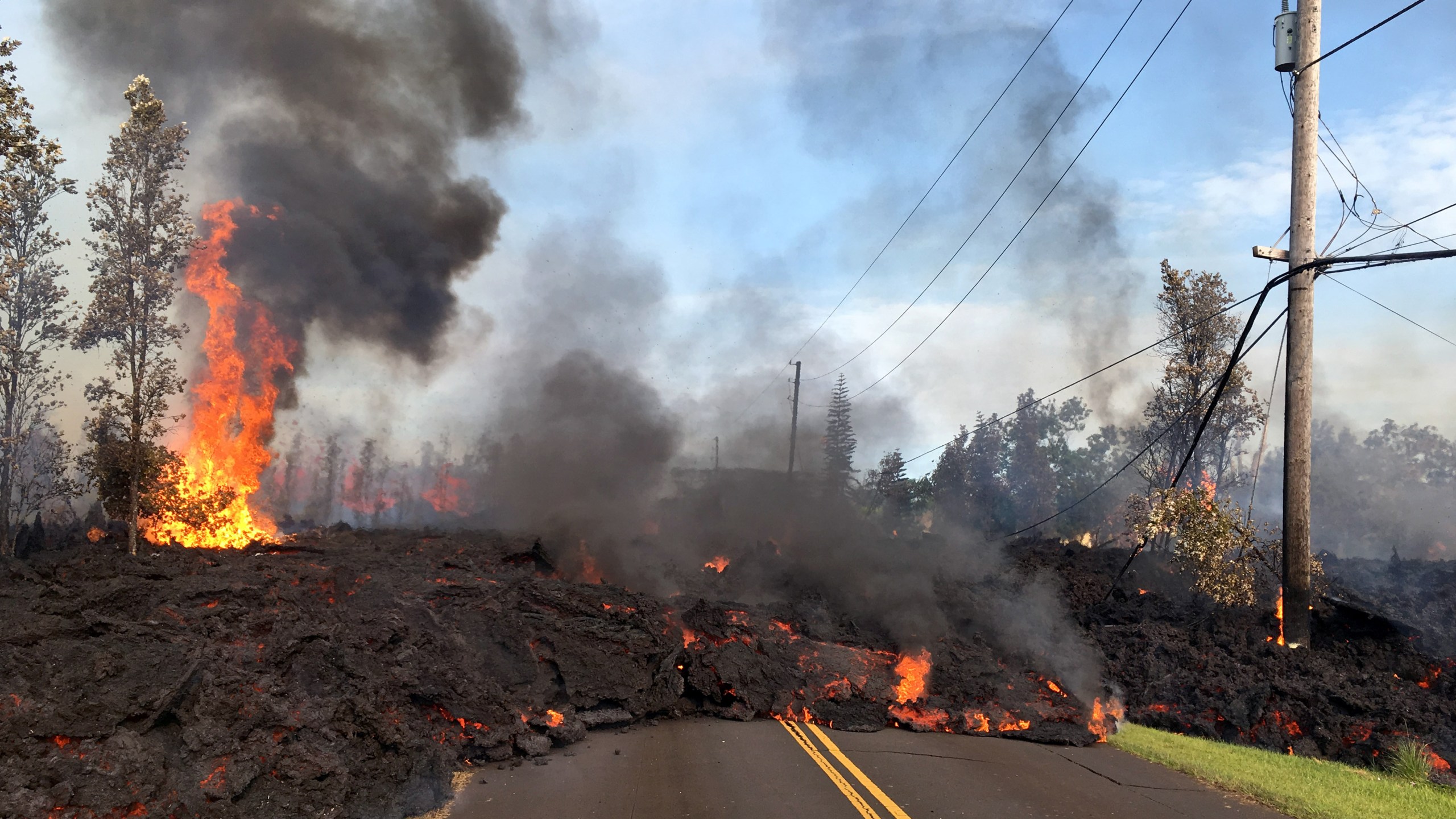 In this handout photo provided by the U.S. Geological Survey, lava from a fissure slowly advances to the northeast on Hookapu Street after the eruption of Hawaii's Kilauea volcano on May 5, 2018 in the Leilani Estates subdivision near Pahoa, Hawaii. (Credit: U.S. Geological Survey via Getty Images)