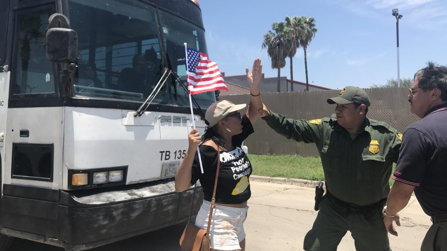 A protester stands in front of a bus with children leaving a McAllen, Texas, detention center on June 23, 2018. (Credit: Sonia Moghe/CNN)