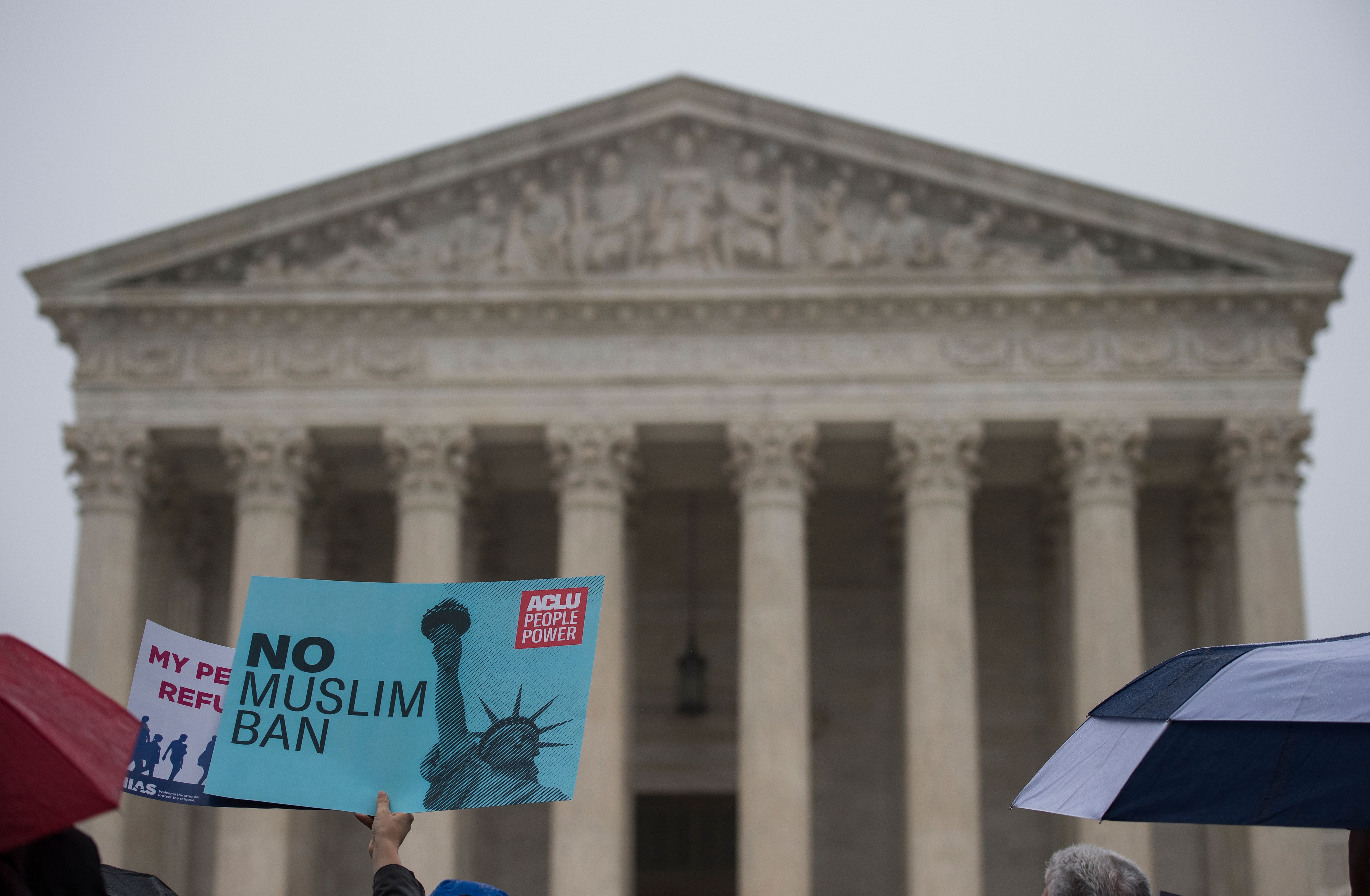 Activists rally against President Donald Trump's travel ban on April 25, 2018 — the day the Supreme Court heard arguments in Hawaii v. Trump — in front of the court in Washington, DC. (Credit: ANDREW CABALLERO-REYNOLDS / AFP / Getty Images)