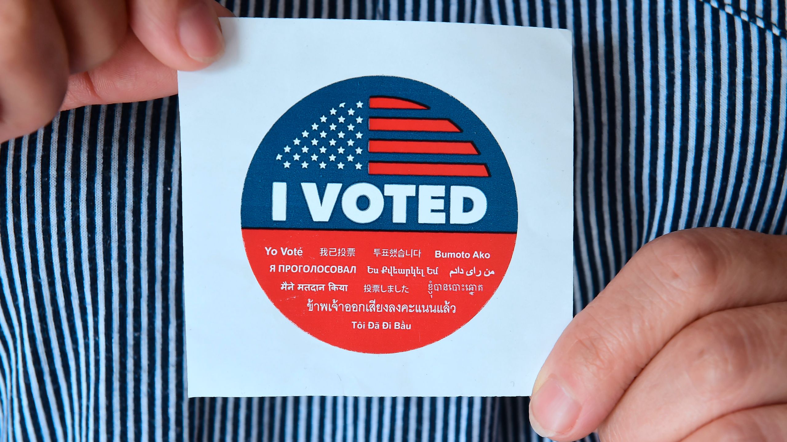 A woman displays a sticker given to voters outside a polling station in Los Angeles on June 5, 2018. (Credit: Frederic J. Brown / AFP / Getty Images)