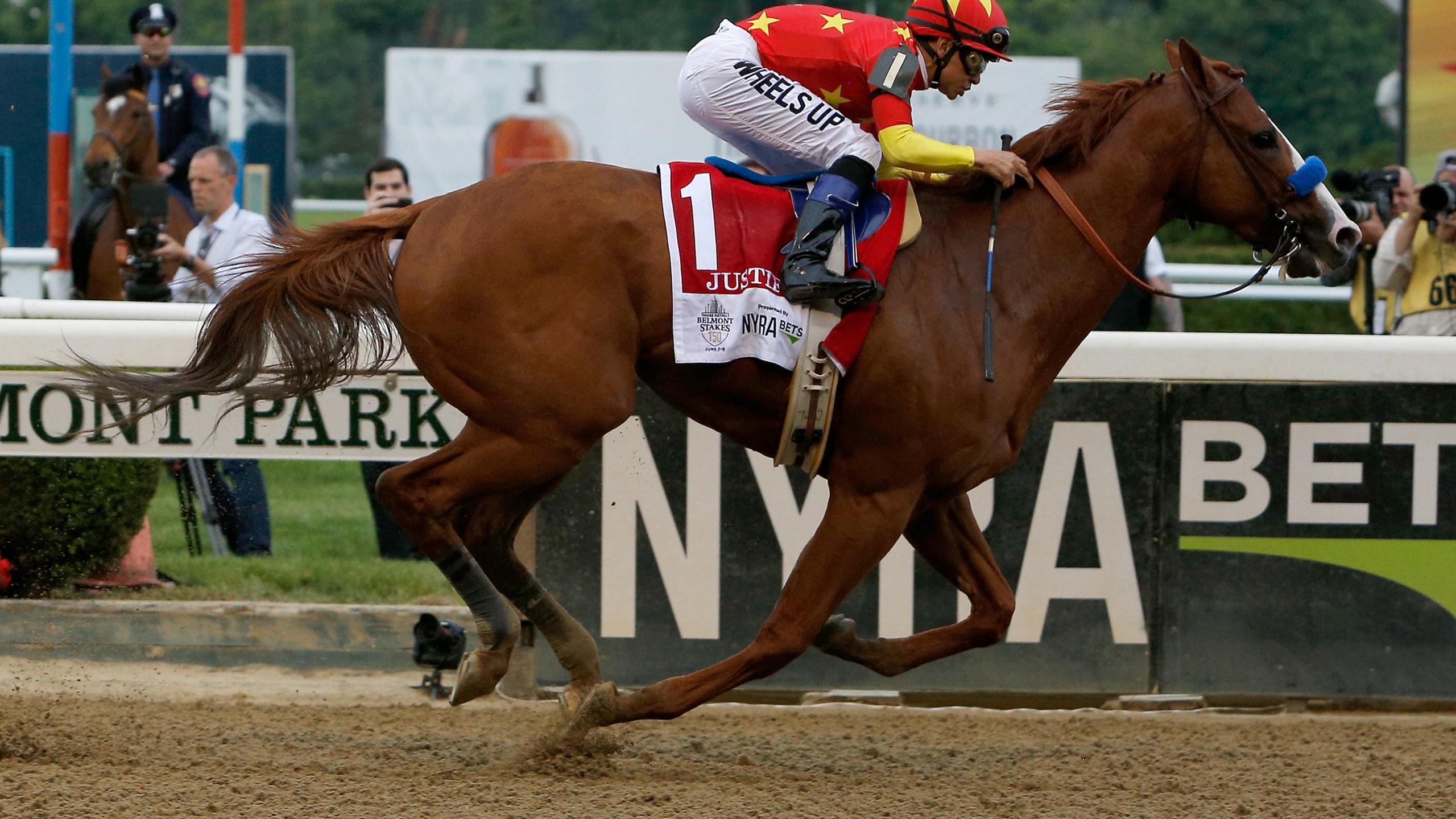 Justify #1, ridden by jockey Mike Smith, crosses the finish line to win the 150th running of the Belmont Stakes at Belmont Park on June 9, 2018, in Elmont, New York. (Michael Reaves/Getty Images)