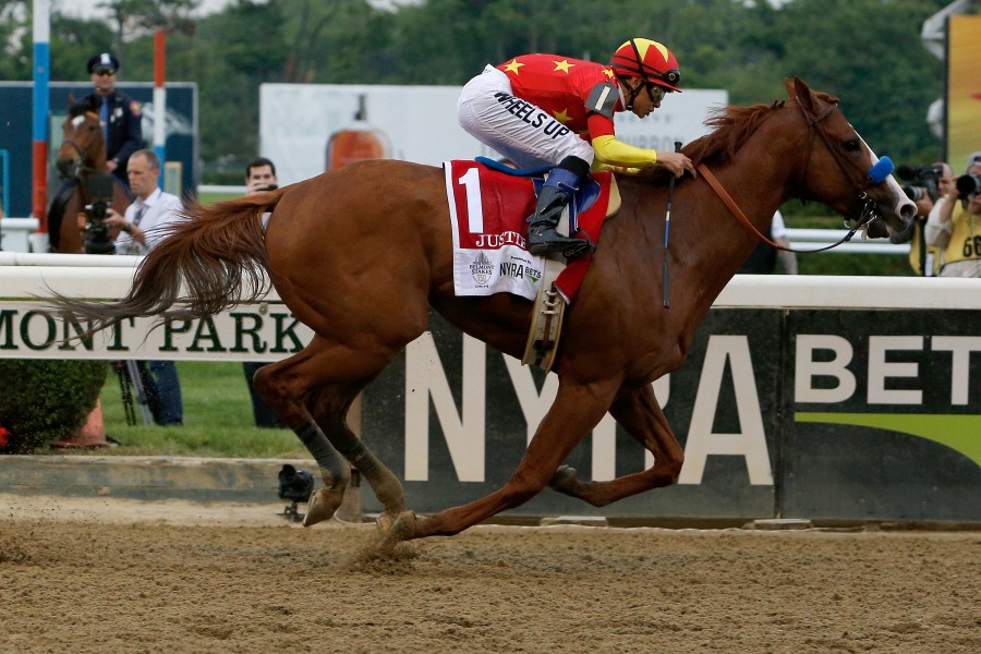 Justify #1, ridden by jockey Mike Smith, crosses the finish line to win the 150th running of the Belmont Stakes at Belmont Park on June 9, 2018, in Elmont, New York. (Michael Reaves/Getty Images)