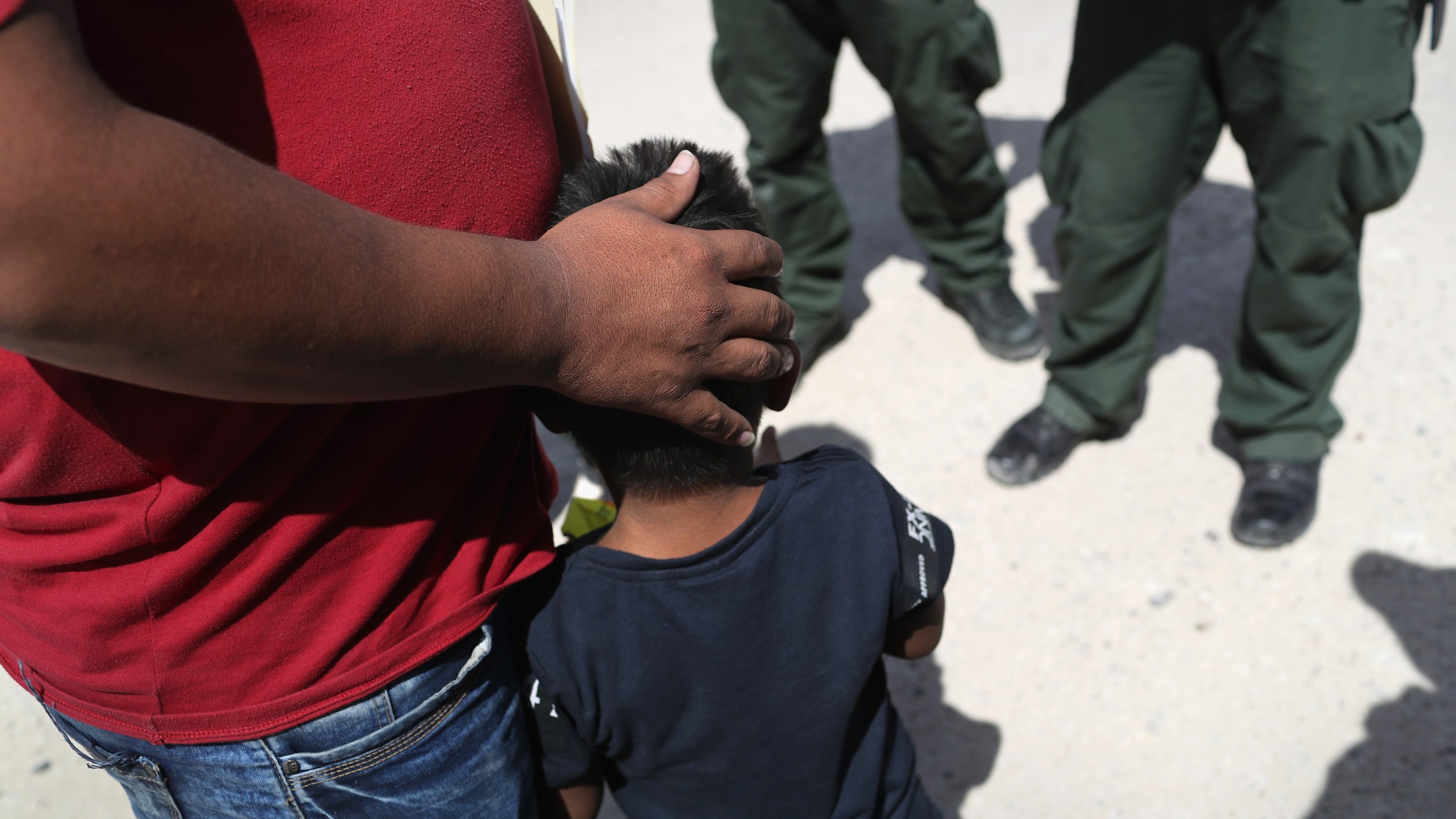 Border Patrol agents take a father and son from Honduras into custody near the U.S.-Mexico border on June 12, 2018, near Mission, Texas. (Credit: John Moore / Getty Images)