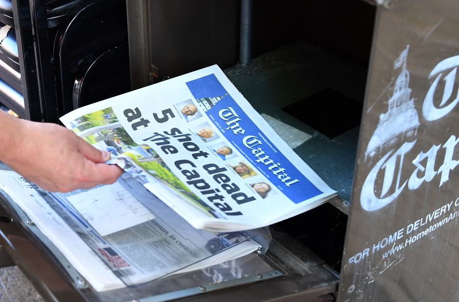 A reporter buys a Capital Gazette newspaper on June 29, 2018, in Annapolis, Maryland, a day after a gunman five people at the publication's office. (Credit: MANDEL NGAN/AFP/Getty Images)