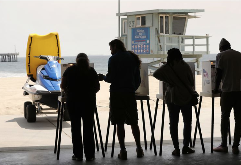 From left, Gigi Grase, Jordan Loth, Glenita and husband Rick Famuyiwa, vote at the Venice Beach Lifeguard Operations Headquarters with a Venice Beach backdrop on June 5, 2018. (Credit: Al Seib / Los Angeles Times)