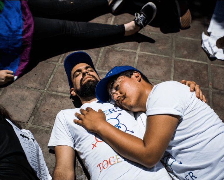 Noah Reich, left, and Dave Maldonado take part in a "die-in" at Los Angeles City Hall on June 12, 2018, to protest gun violence in America. (Credit: Gabriel S. Scarlett / Los Angeles Times)