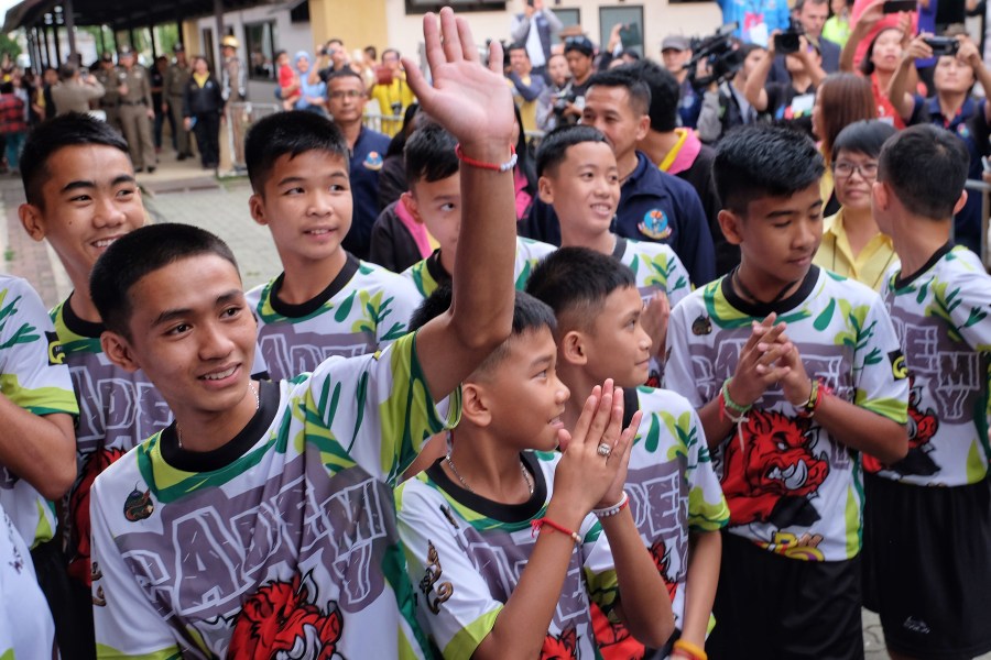 Twelve boys and their coach from the 'Wild Boars' soccer team arrive for a press conference for the first time since they were rescued from a cave in northern Thailand last week, on July 18, 2018 in Chiang Rai, Thailand. (Credit: Linh Pham/Getty Images)