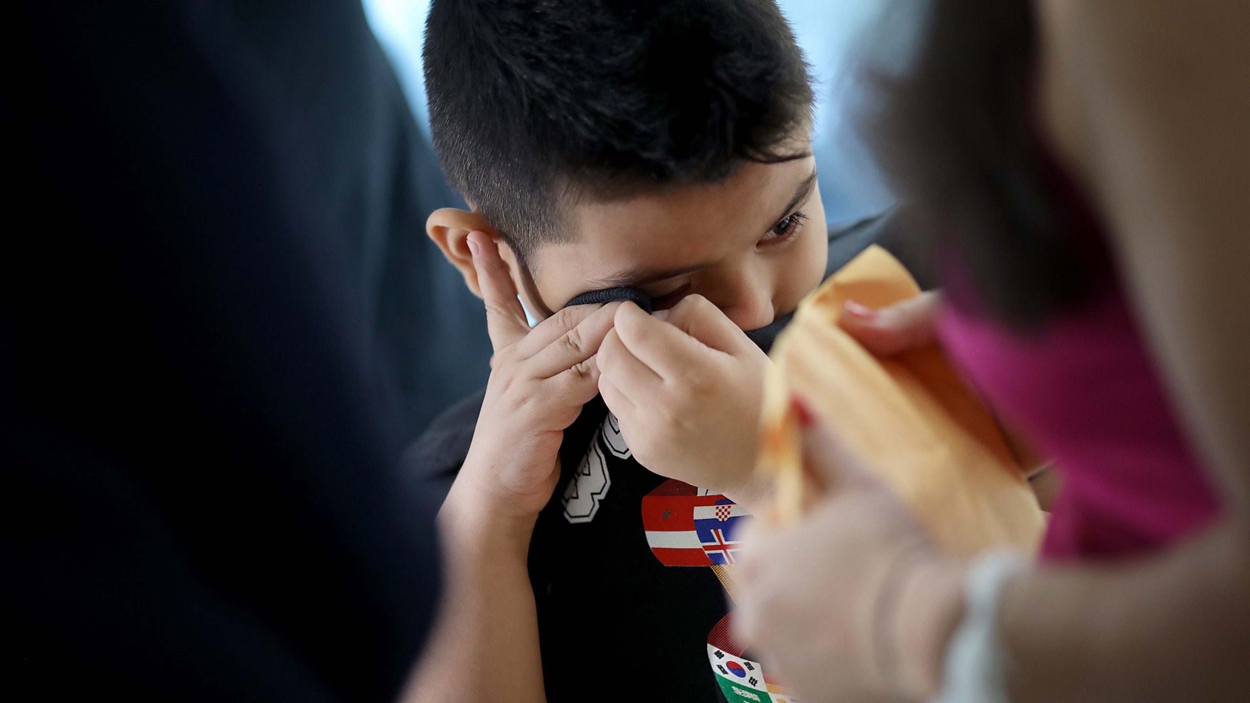 7-year-old Andy wipes tears from his eyes after being reunited with his mother, Arely, at Baltimore-Washington International Airport on July 23, 2018. (Credit: Win McNamee / Getty Images)