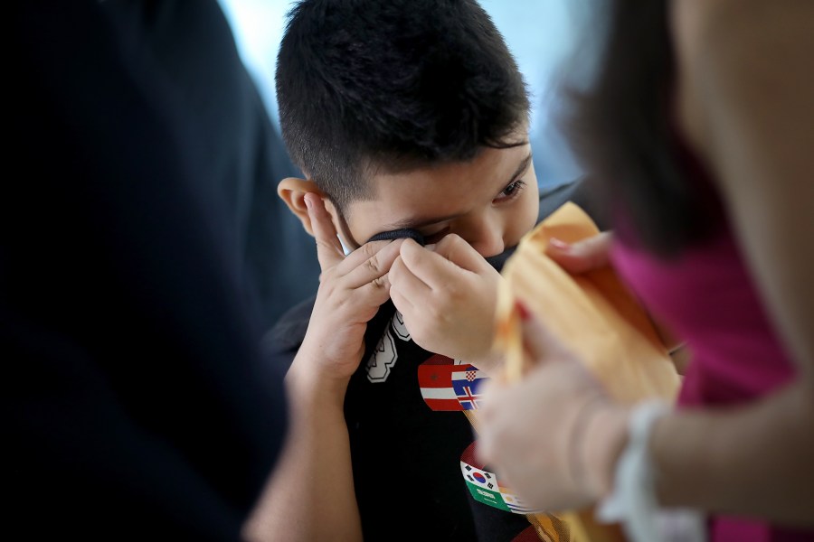 7-year-old Andy wipes tears from his eyes after being reunited with his mother, Arely, at Baltimore-Washington International Airport on July 23, 2018. (Credit: Win McNamee / Getty Images)