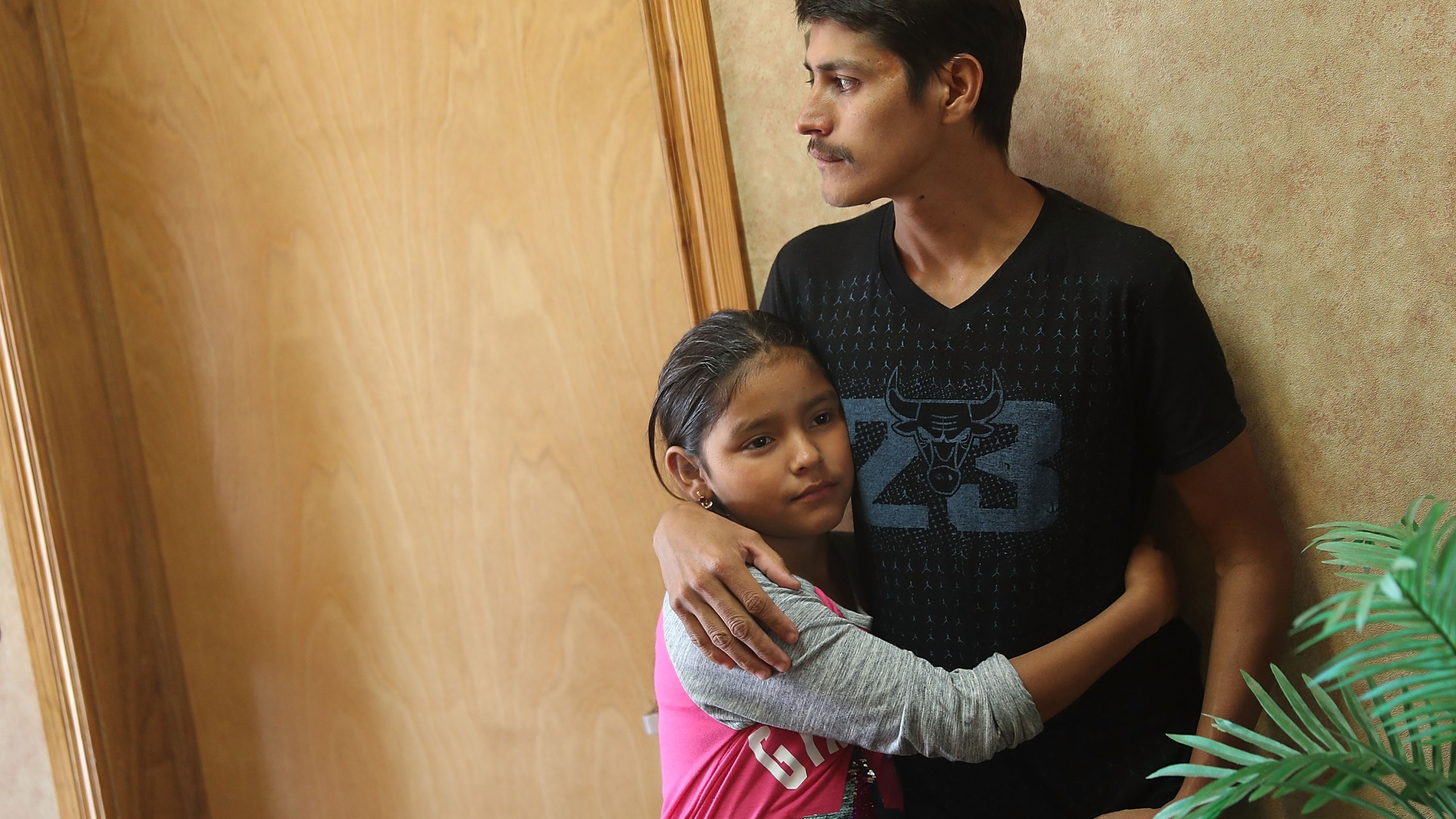 A man, identified only as Leon, spends time with his 11-year-old daughter Anaveli as they are cared for in an Annunciation House facility after they were reunited with each other on July 25, 2018 in El Paso, Texas. (Credit: Joe Raedle / Getty Images)