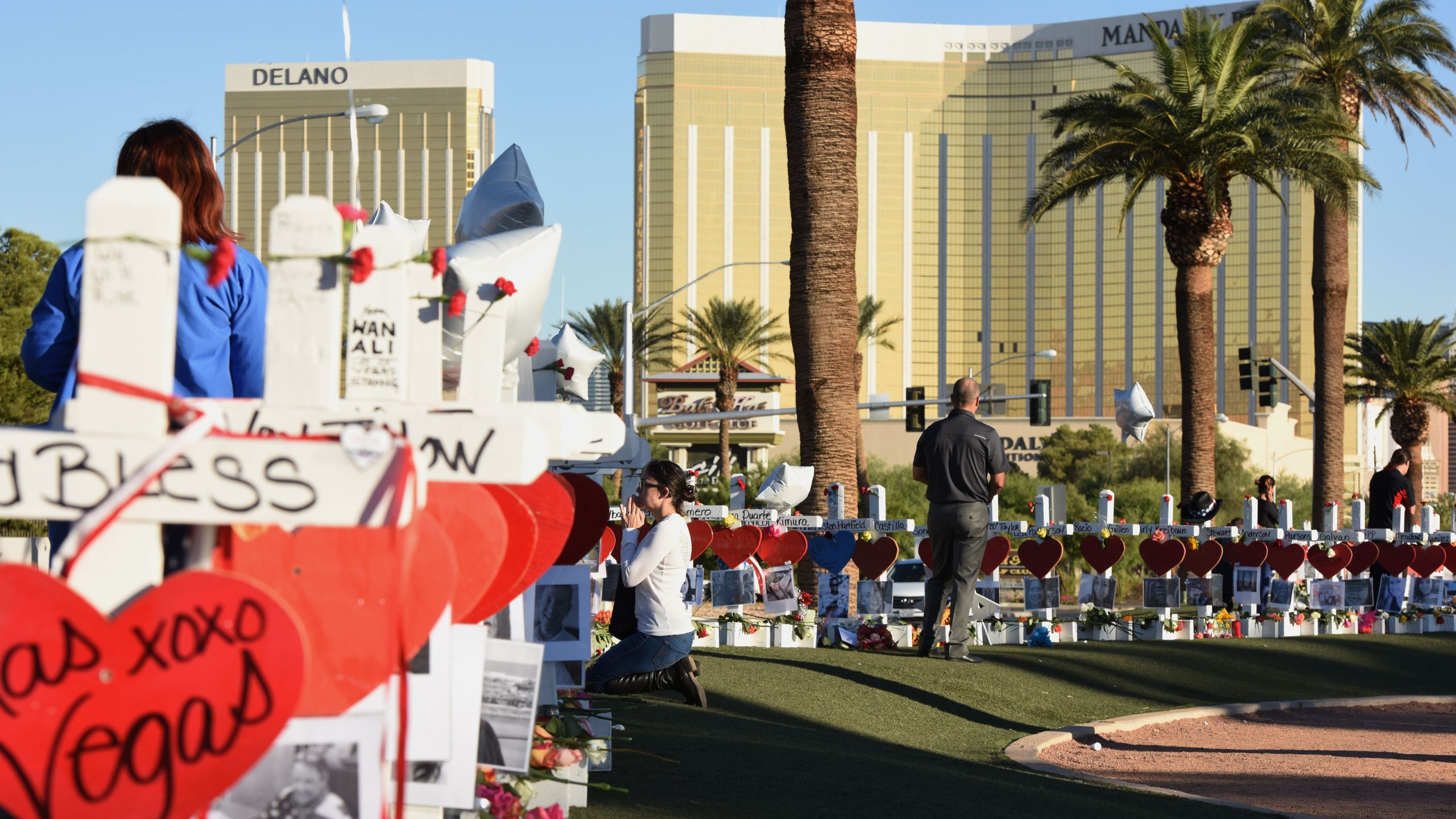 A woman prays beside 58 white crosses for the victims of a mass shooting on the Las Vegas Strip just south of the Mandalay Bay hotel on Oct. 6, 2017. (Credit: ROBYN BECK/AFP/Getty Images)