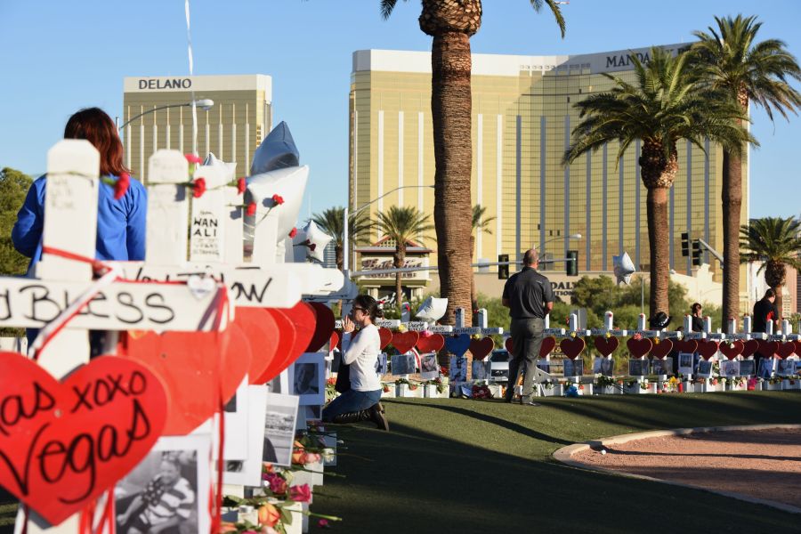 A woman prays beside 58 white crosses for the victims of a mass shooting on the Las Vegas Strip just south of the Mandalay Bay hotel on Oct. 6, 2017. (Credit: ROBYN BECK/AFP/Getty Images)