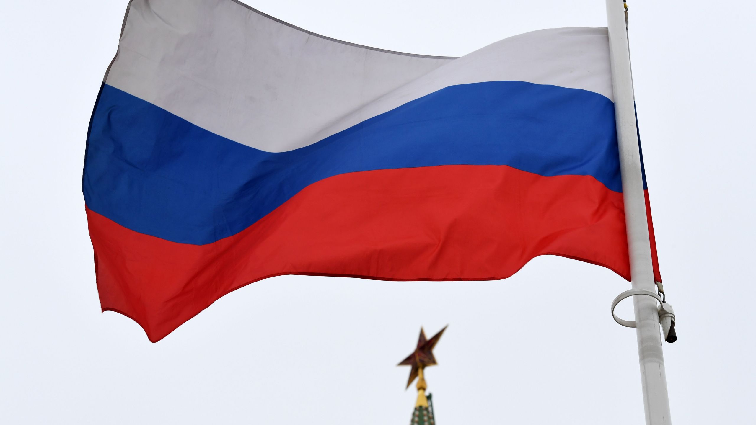 A Russian flag flies in front of a ruby star atop one of the Kremlin's towers in downtown Moscow on March 13, 2018.