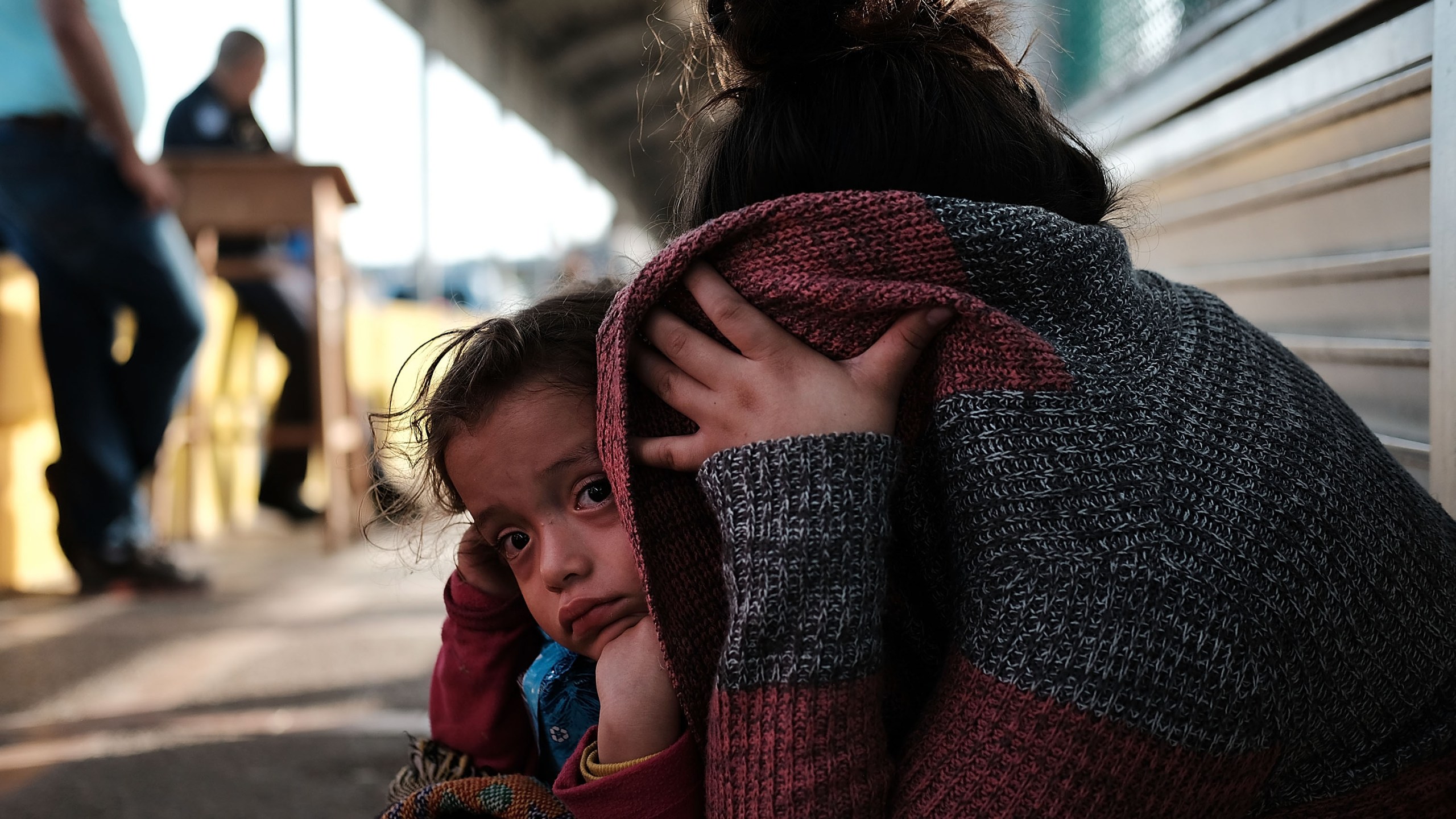 A Honduran child and her mother, fleeing poverty and violence in their home country, waits along the border bridge after being denied entry from Mexico into the U.S. on June 25, 2018 in Brownsville, Texas. (Credit: Spencer Platt/Getty Images)