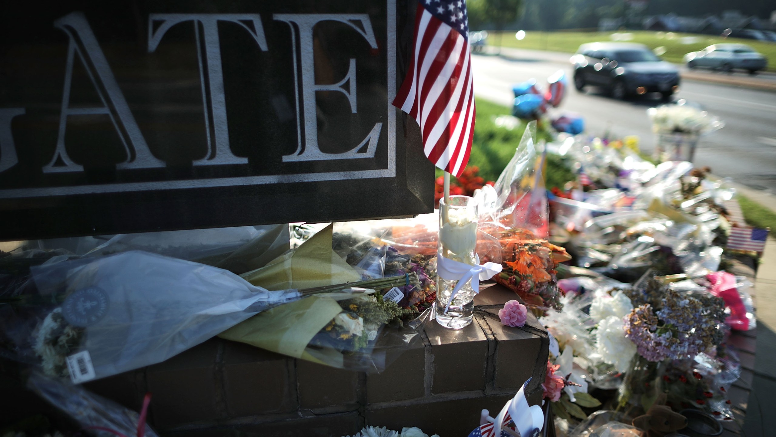 Flowers, flags and hand-written notes are gathered in a makeshift memorial outside the Capitol Gazette offices in Annapolis, Maryland, on July 2, 2018, for the employees killed by a gunman the week before. (Credit: Chip Somodevilla / Getty Images)